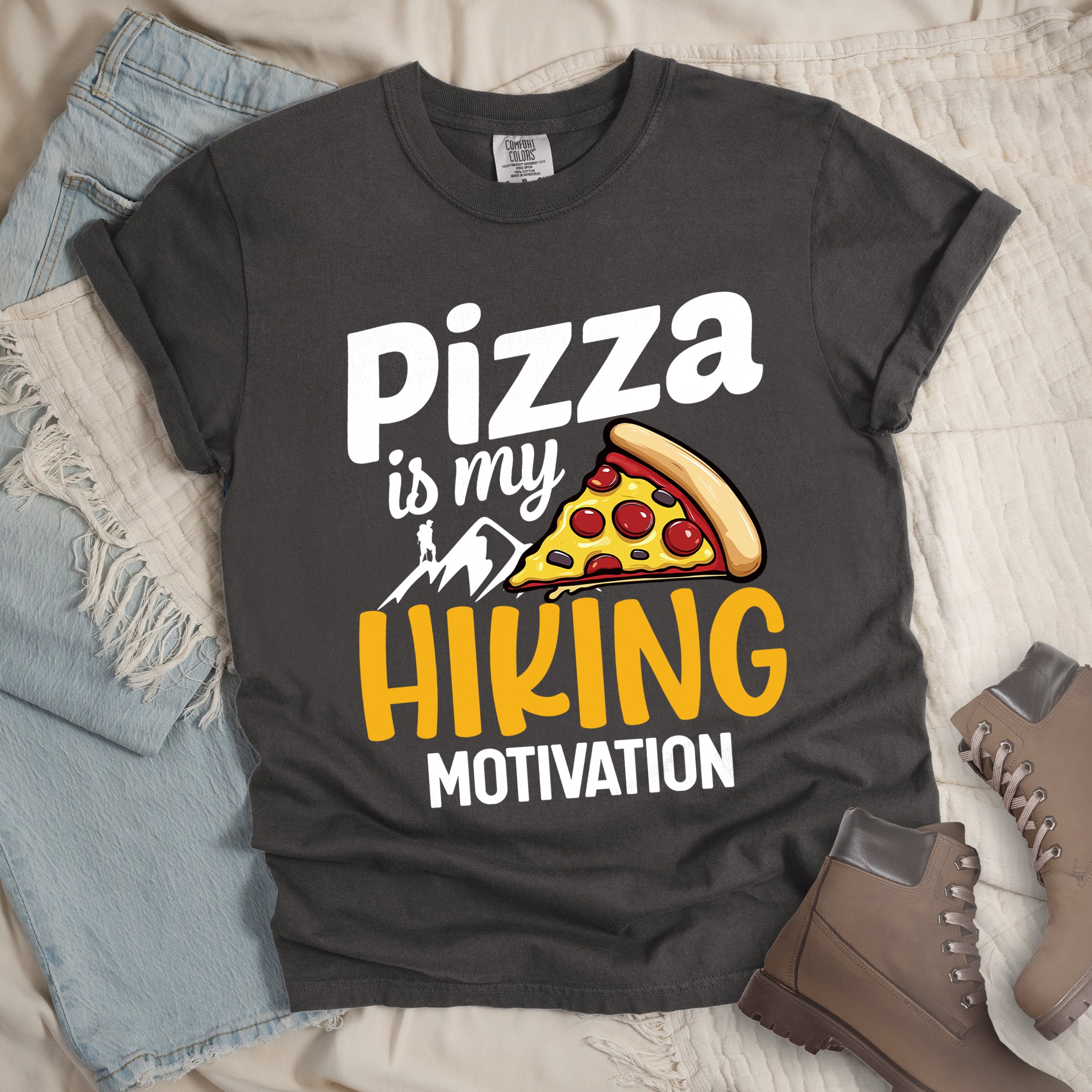 Pepper (Dark Gray) t-shirt with orange text reading "HIKING For BIRYANI". "HIKING" appears in large orange letters at the top, "For" in white script in the middle, and "BIRYANI" in orange at the bottom. Features a detailed illustration of a blue bowl filled with yellow biryani rice and meat pieces in the center, bright orange mountain silhouettes in the background, and an orange hiker silhouette on the right side.