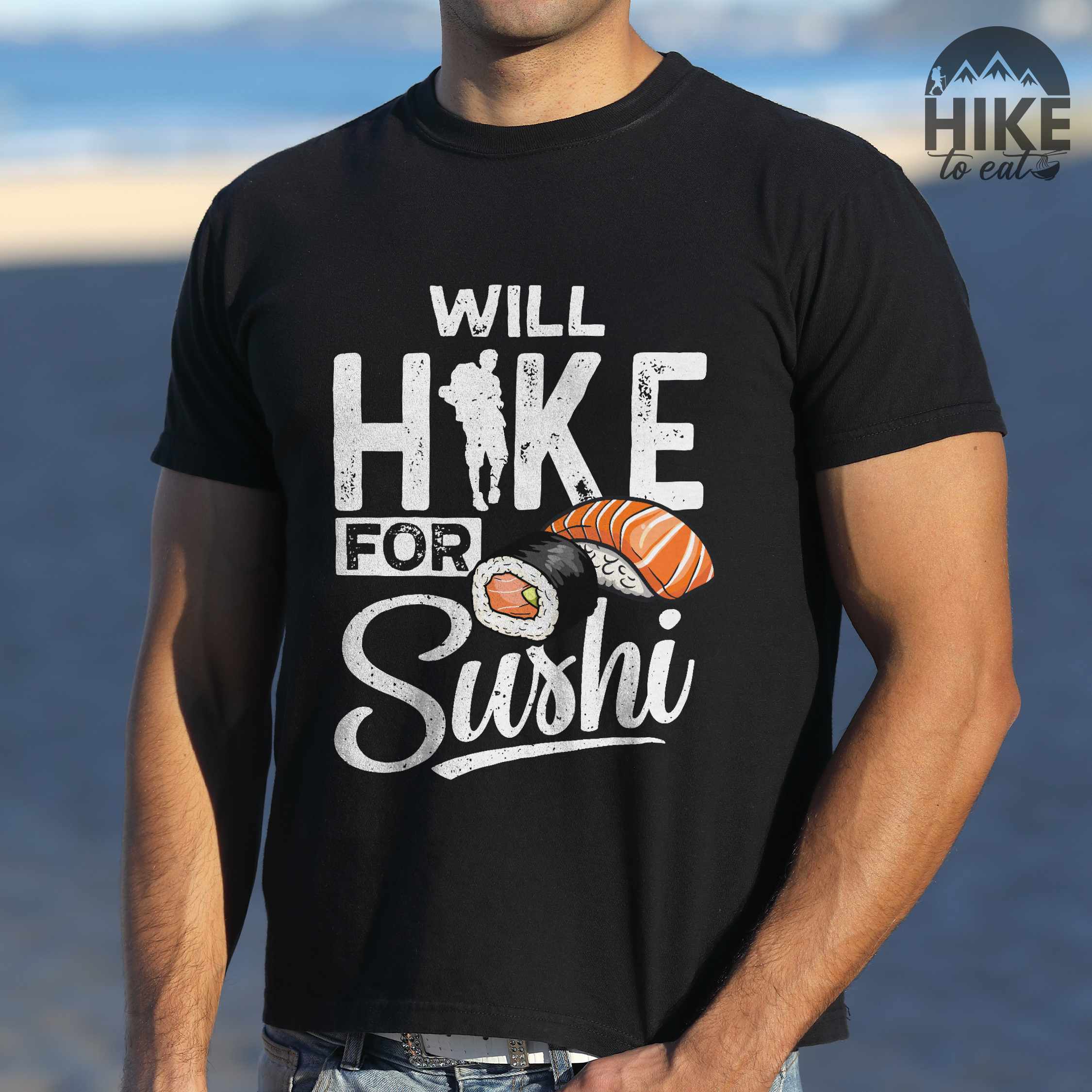 Man wearing black "Will hike for sushi" colored vintage tee with bold typography, birds, mountains, illustrated sushi platter, and backpacker for sushi lovers.