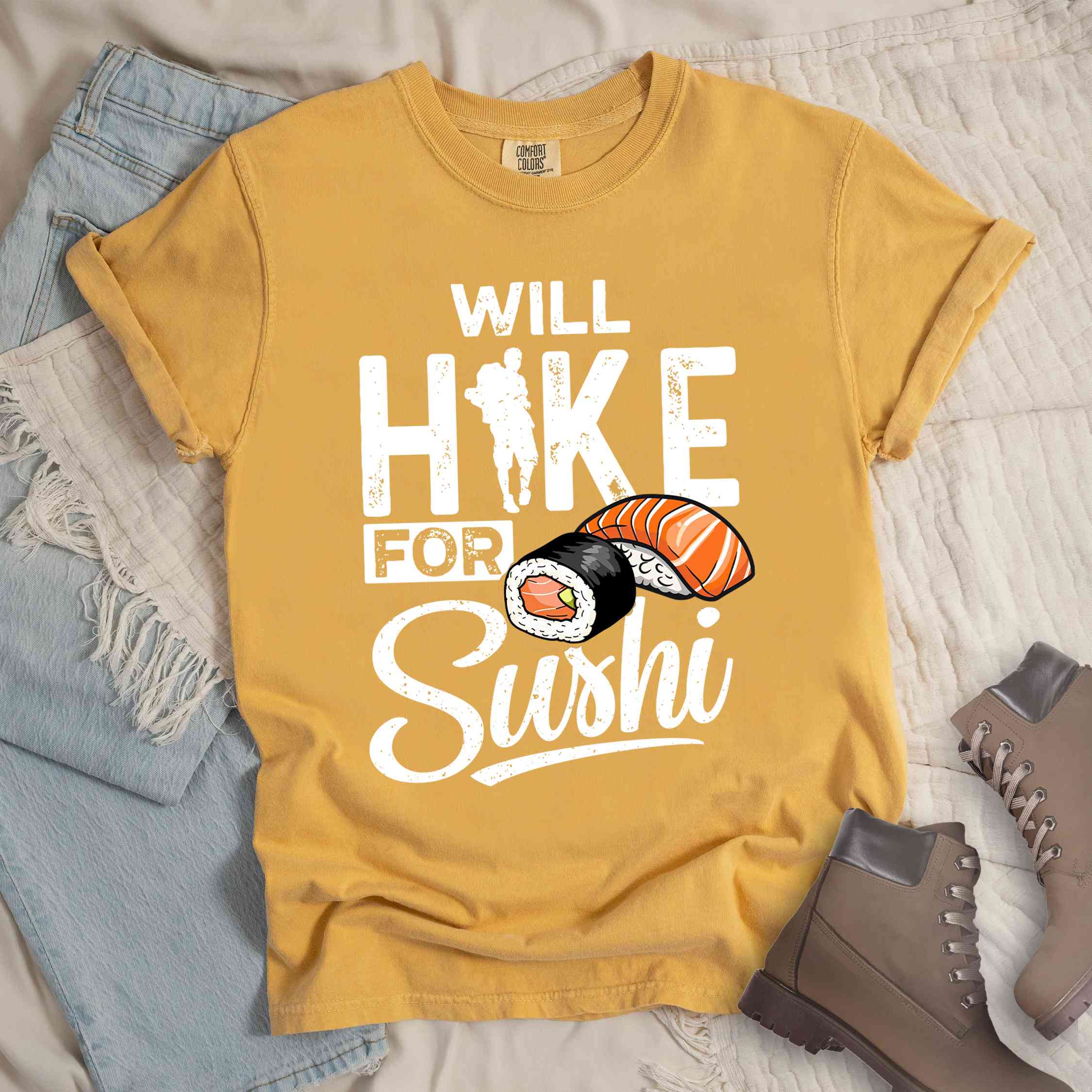 Mustard "Will hike for sushi" colored vintage tee with bold typography, birds, mountains, illustrated sushi platter, and backpacker for sushi lovers.