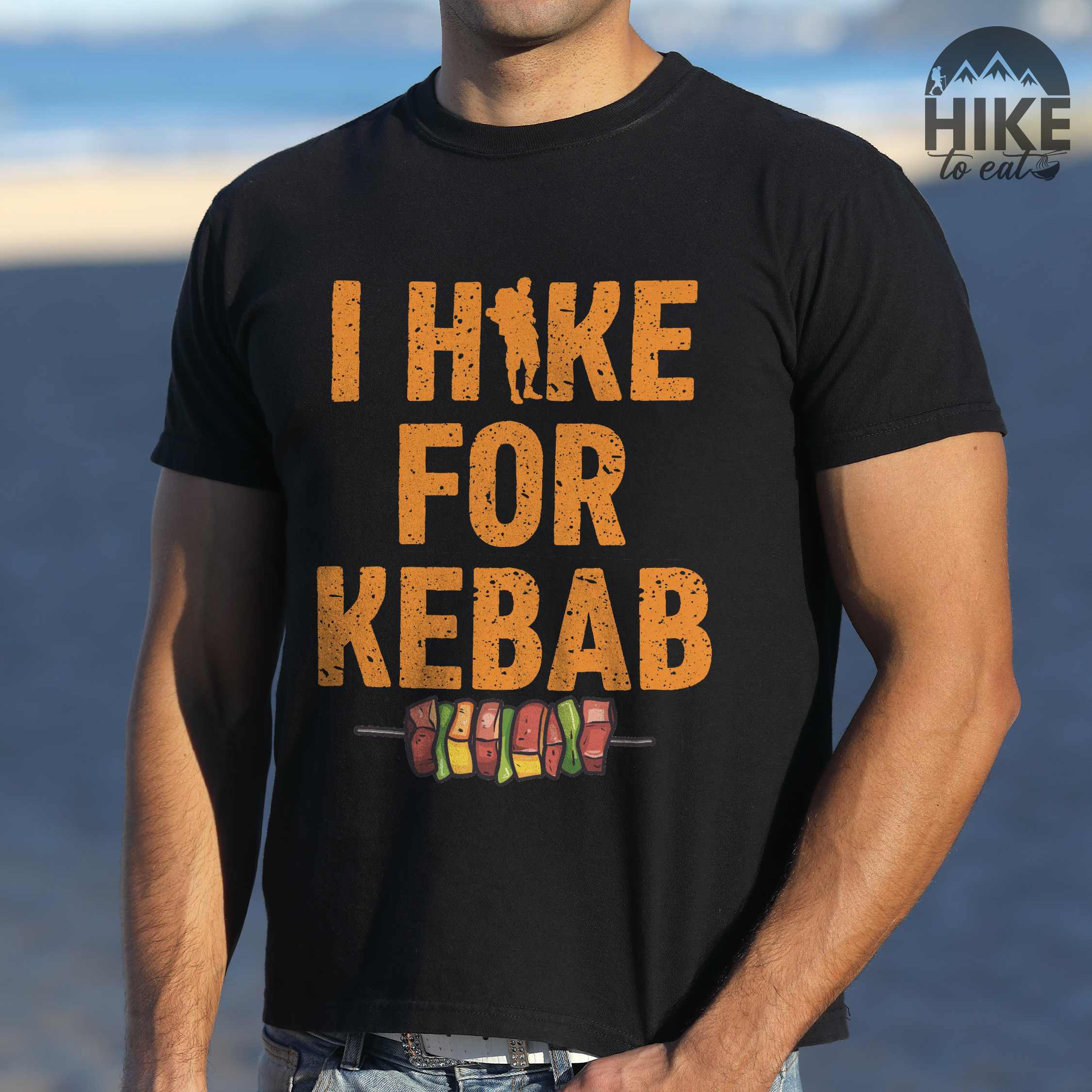 Man wearing black "I hike for kebab" colored vintage tee with bold typography illustrated grilled kebabt, and backpacker for kebab lovers.