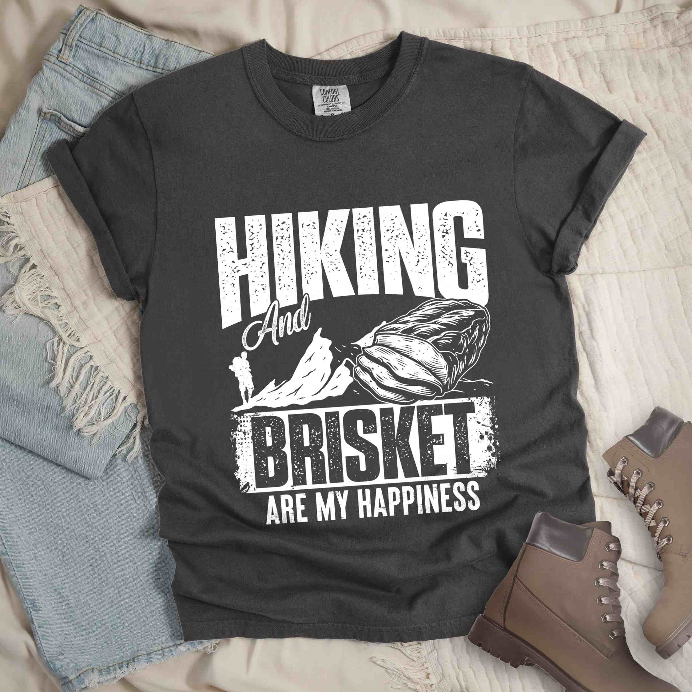 Pepper "hiking and brisket are my happiness" colored vintage tee with bold typography, birds, mountains, illustrated bbq beef brisket, and backpacker for bbq lovers.