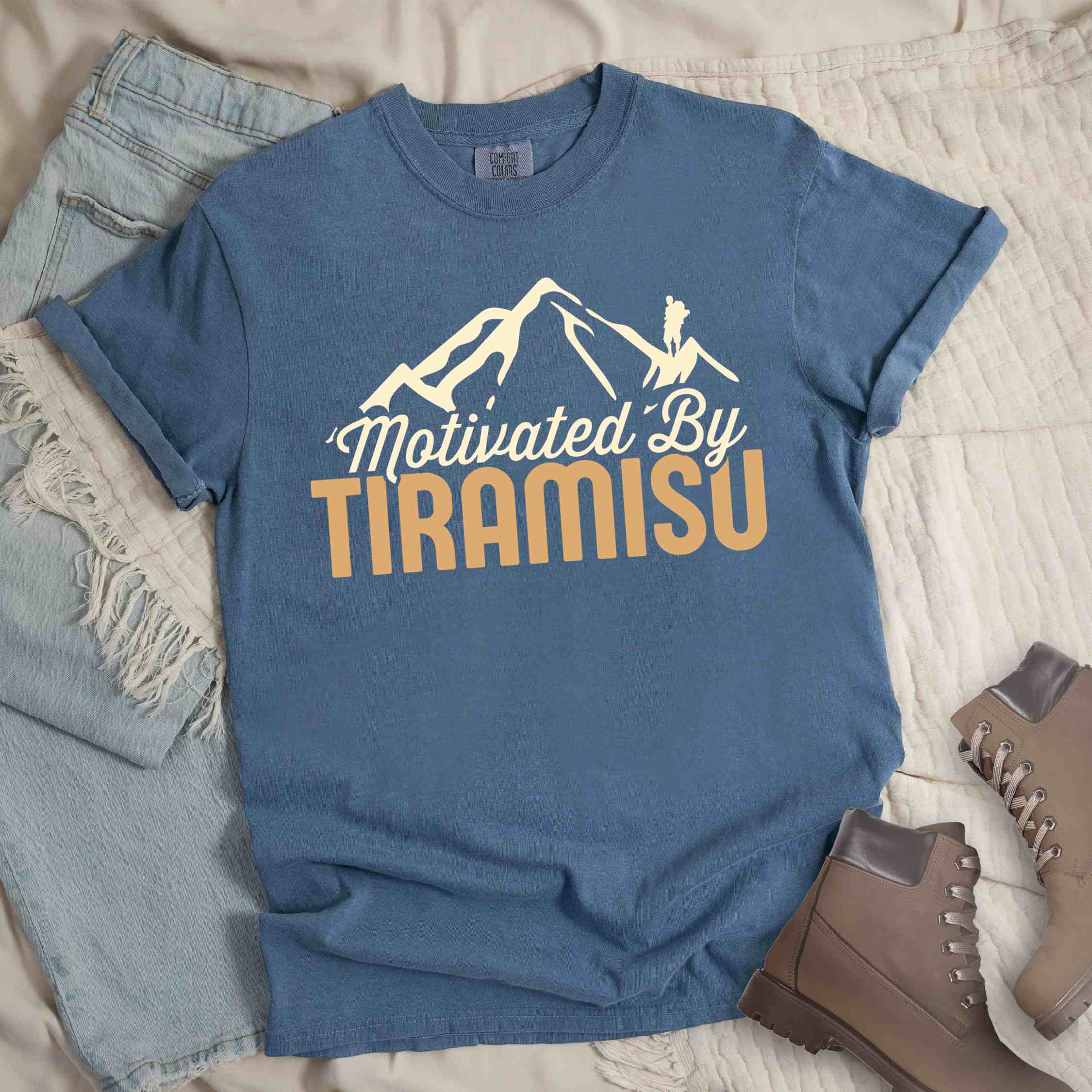 blue jean "Motivated by Tiramisu" colored vintage tee with bold typography, mountains, and backpackers with a sweet tooth.