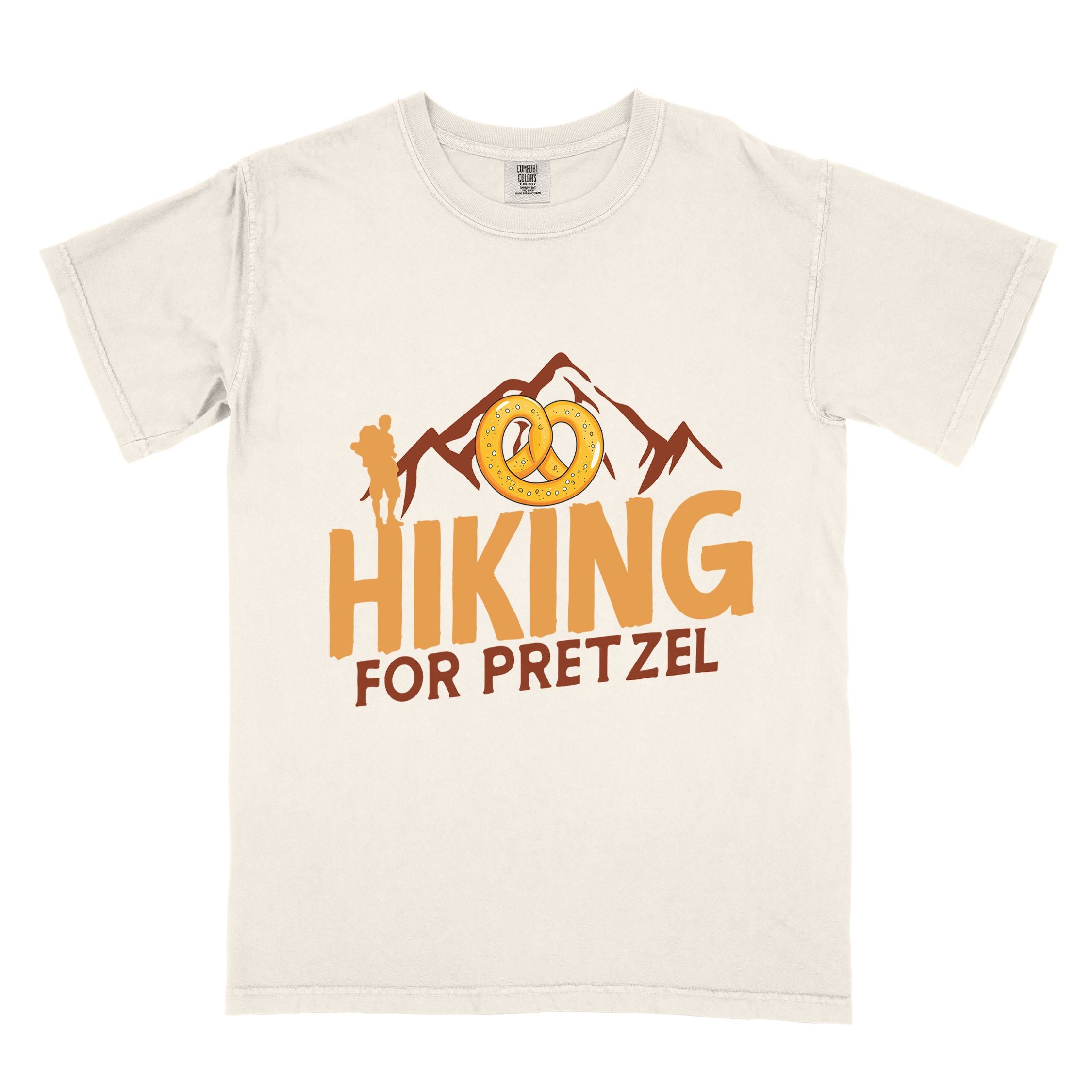 Ivory "Hiking for pretzel" colored vintage tee with bold typography, mountains, birds, and illustrated pretzel for baked pretzel lovers