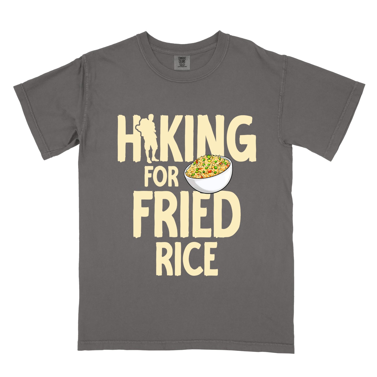 Pepper (Dark Gray) t-shirt with pale yellow text reading "HIKING FOR FRIED RICE". "HIKING" appears at the top with a hiker silhouette integrated into the letter "I", "FOR" in smaller text in the middle, and "FRIED RICE" in large letters at the bottom. Features an illustration of a white bowl filled with colorful fried rice with vegetables next to "FOR" and above "FRIED".