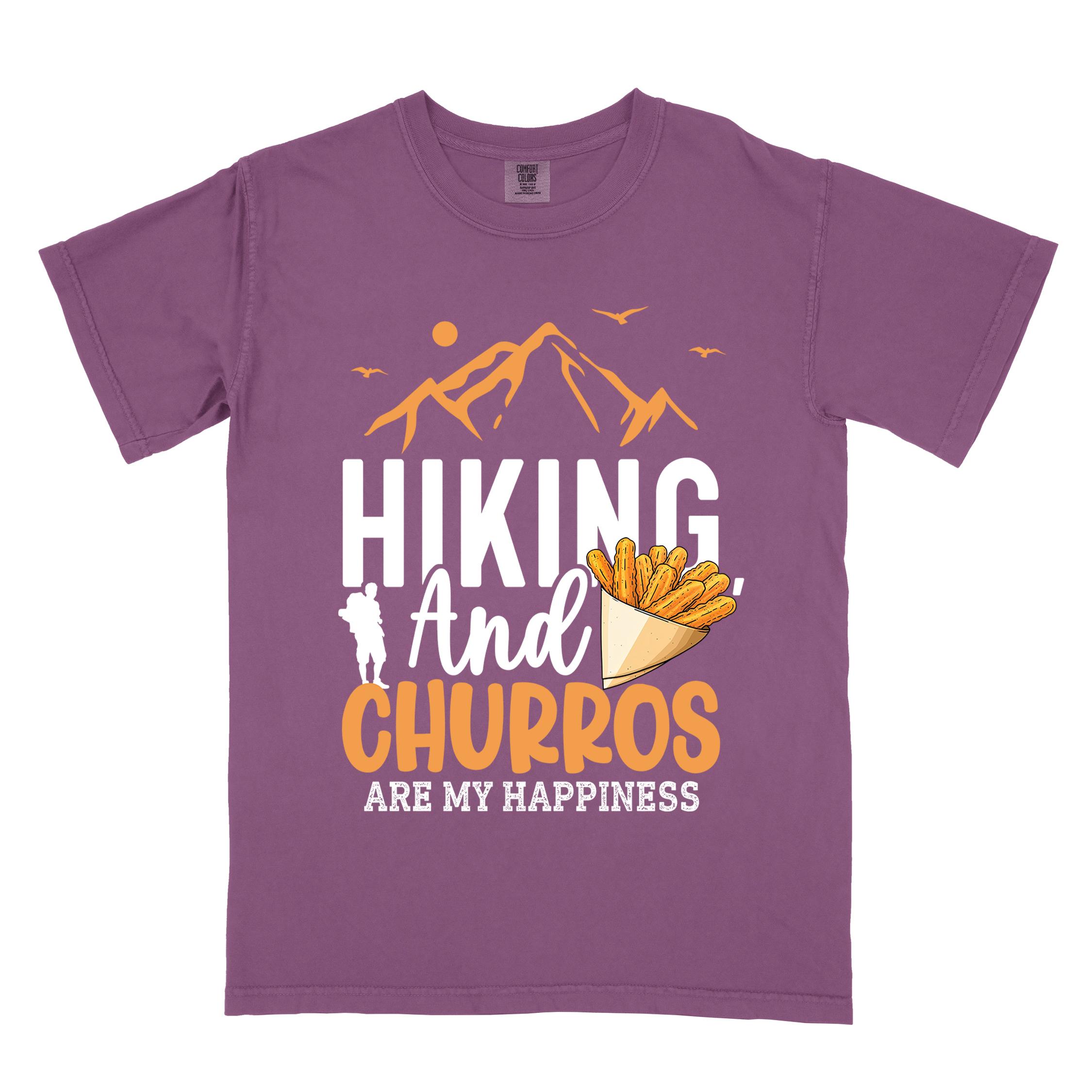 Berry "hiking and churros are my happiness " colored vintage tee with bold typography, mountains, birds, illustrated a serving of Churros, and backpackers with a sweet tooth.