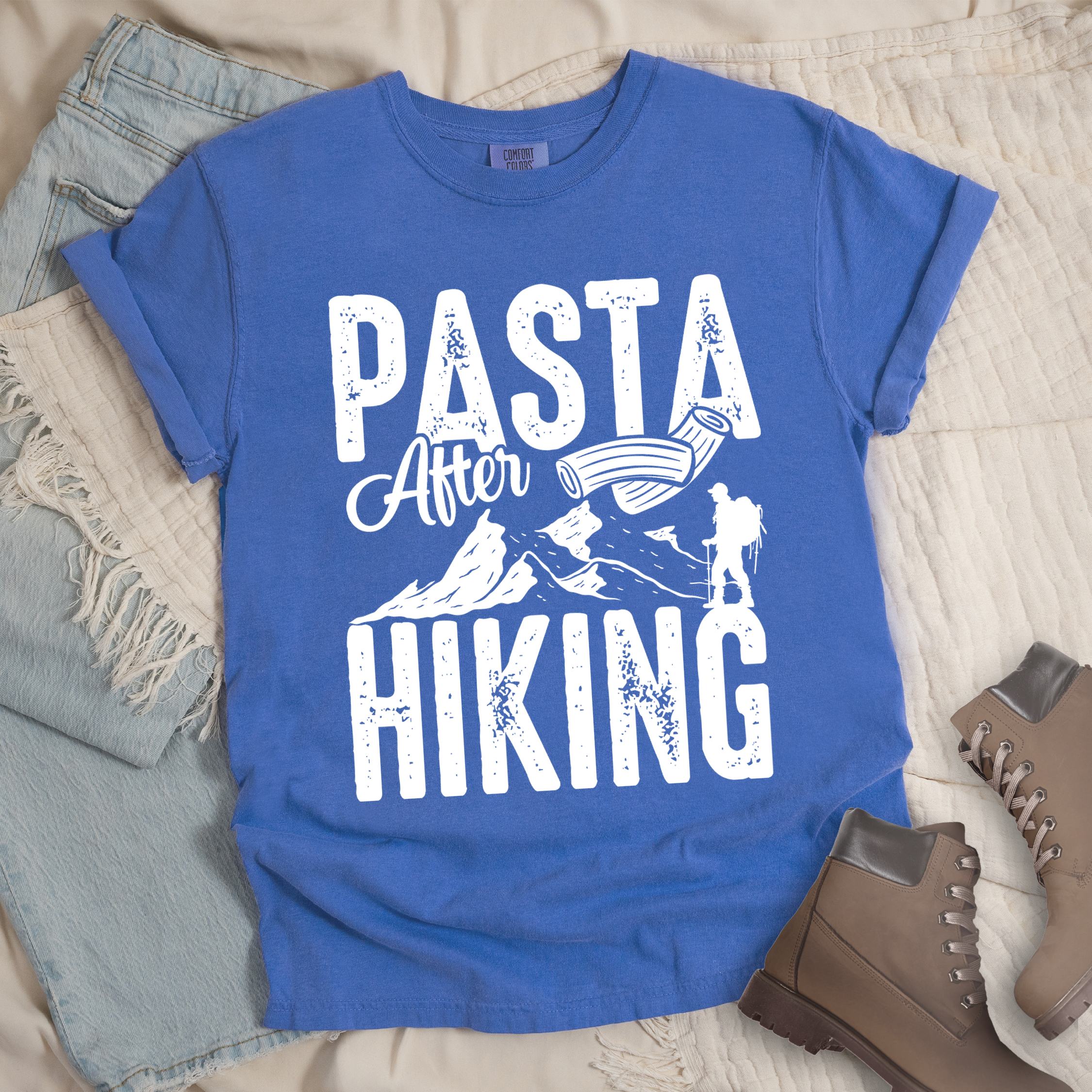 Blue shirt with the phrase “Pasta After Hiking.” Includes a hiker silhouette, mountain outline, and pasta noodle illustration.