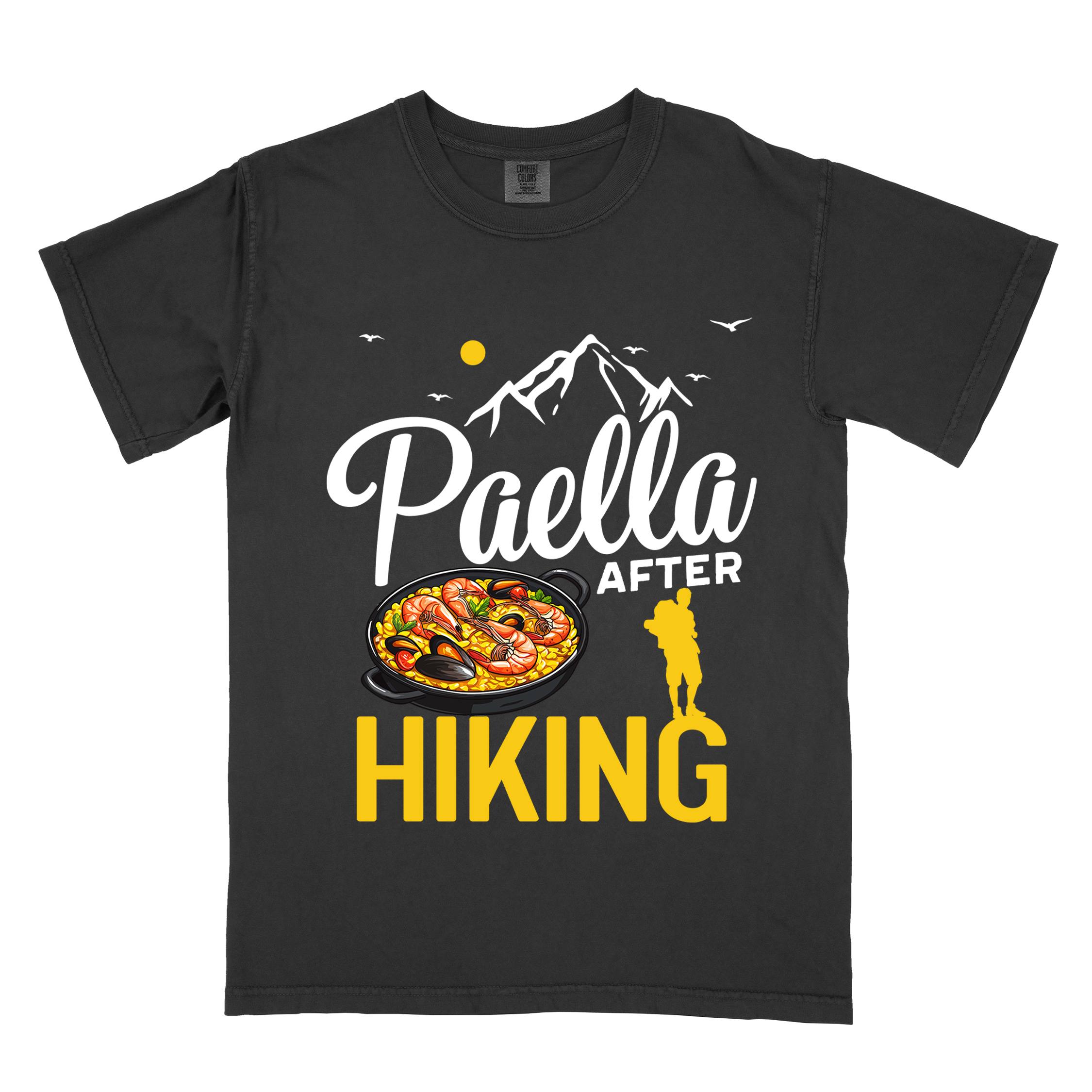 Black "Paella after hiking" colored vintage tee with bold typography, mountains, birds, illustrated paella platter, and backpackers for rice lovers.