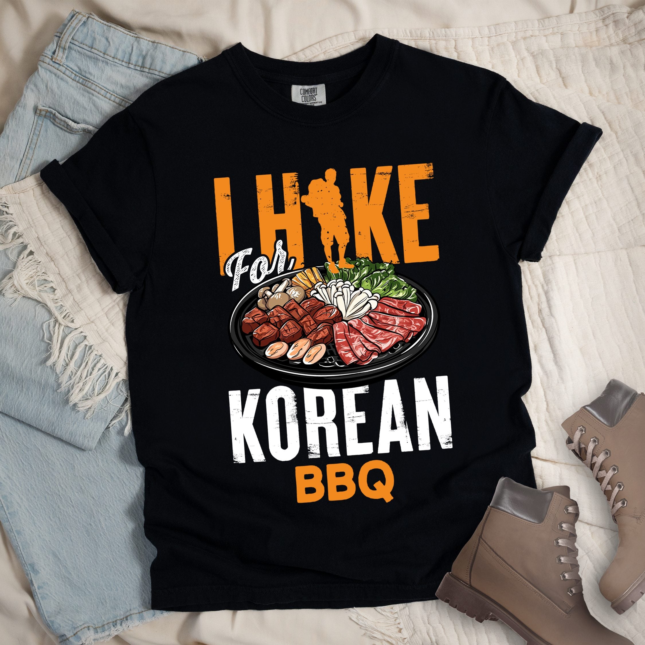 Black shirt with Hiking Design featuring the phrase “I Hike for Korean BBQ” with a hiker silhouette and a platter of Korean barbecue with side dishes.
