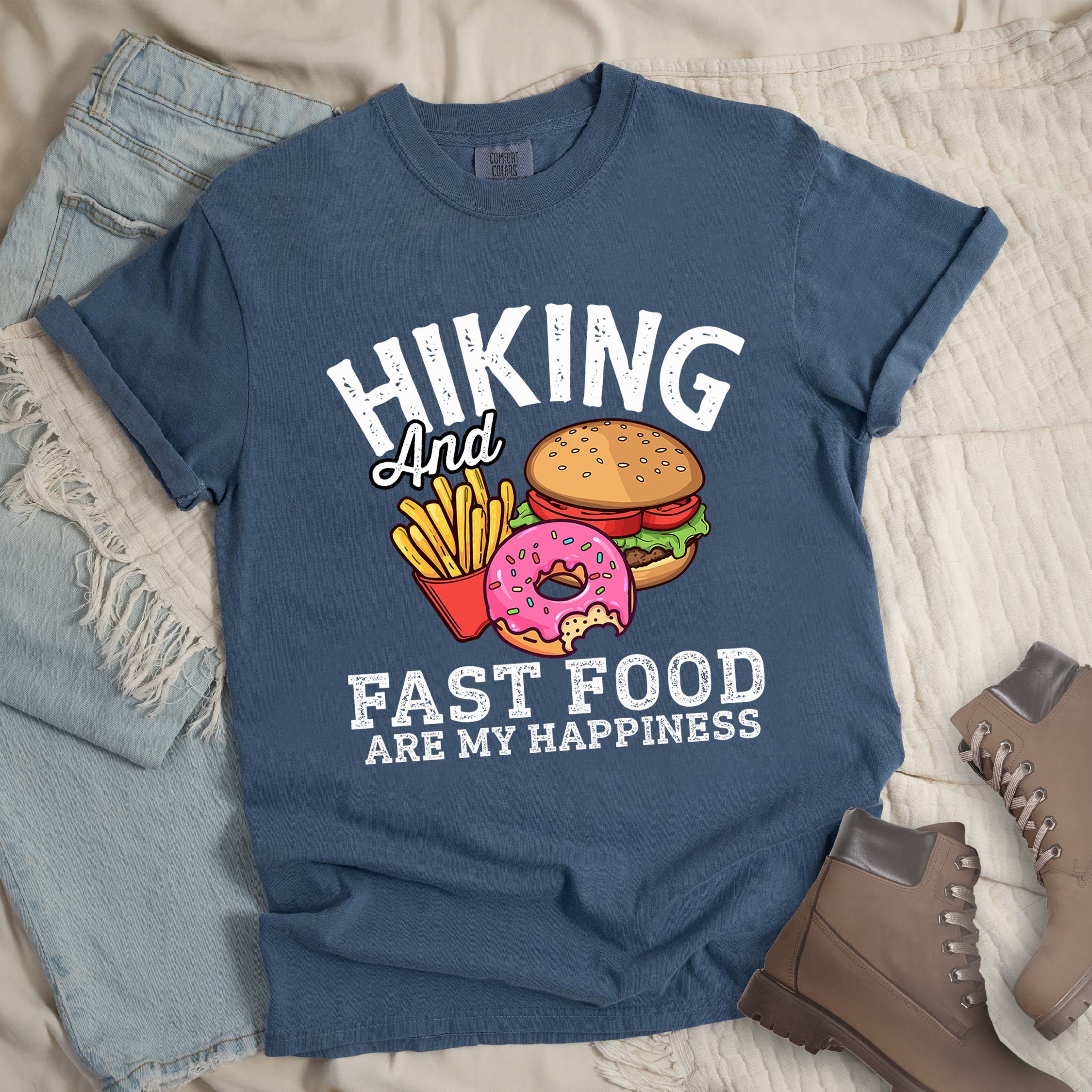 Dark blue shirt showing a hiking design with 'Hiking and fast food are my happiness' phrase and an illustration of fast food meal in front.