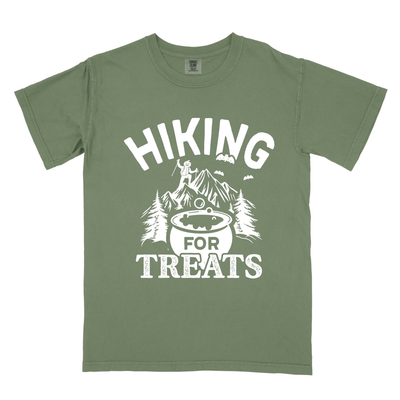 Moss Halloween vintage tee Hiking for Treats featuring curved typography bubbling cauldron with candy mountain landscape with character on peak pine trees and flying bats on Comfort Colors shirt for spooky season celebrations for hikers, foodies and adventurers.