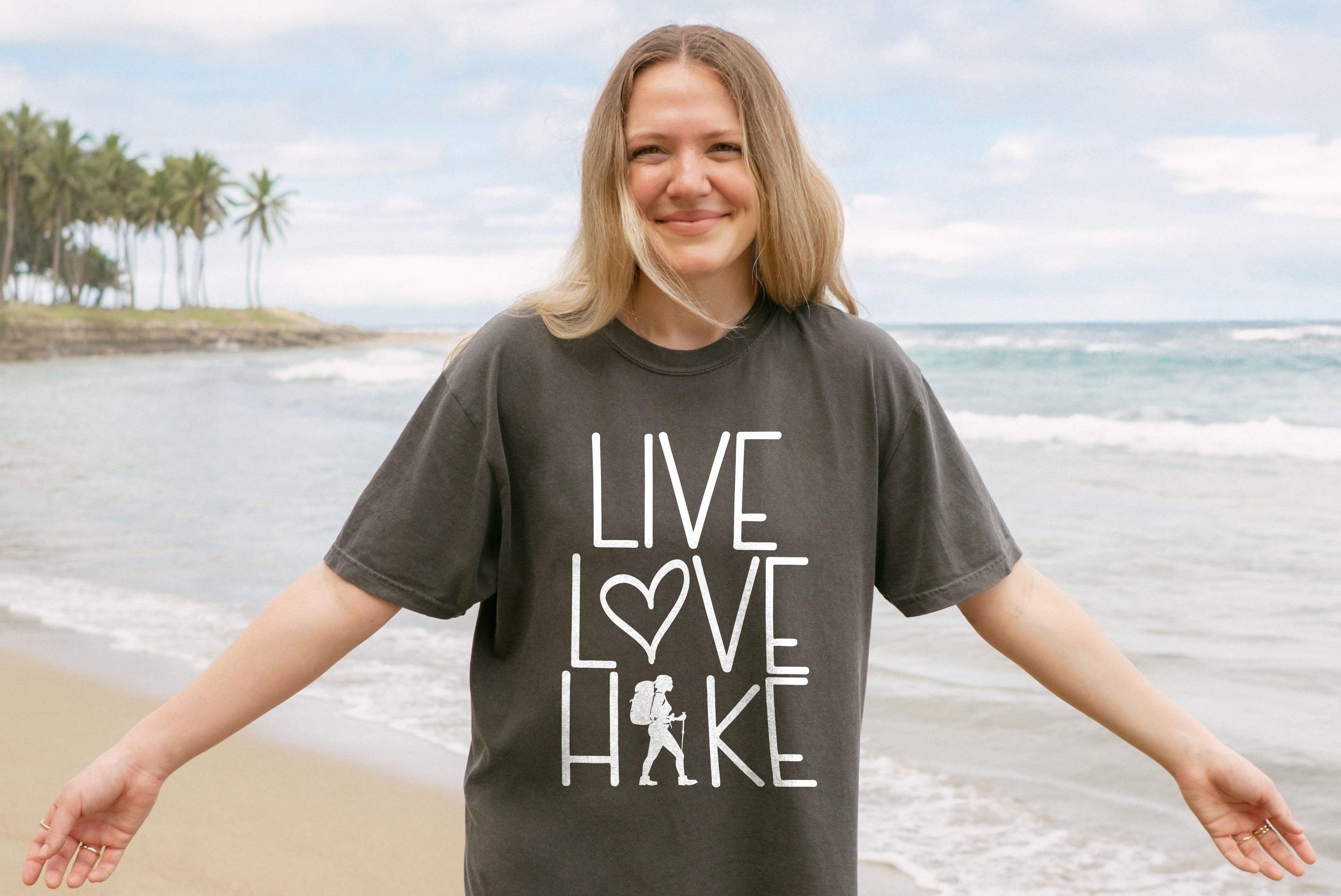 Woman wearing a t-shirt with 'Live Love Hike' on a beach