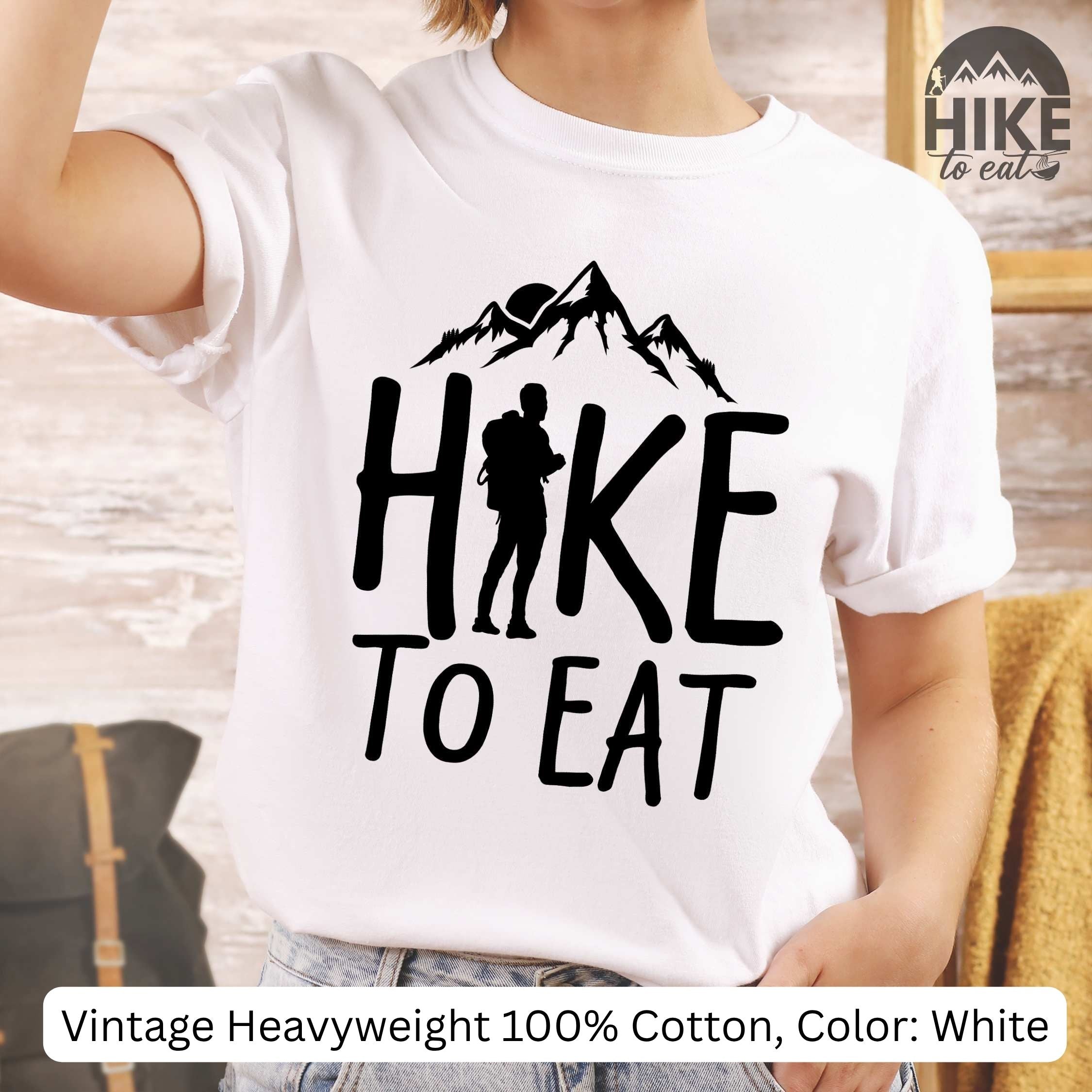 White t-shirt with 'Hike to Eat' design and mountain graphic worn by a person.