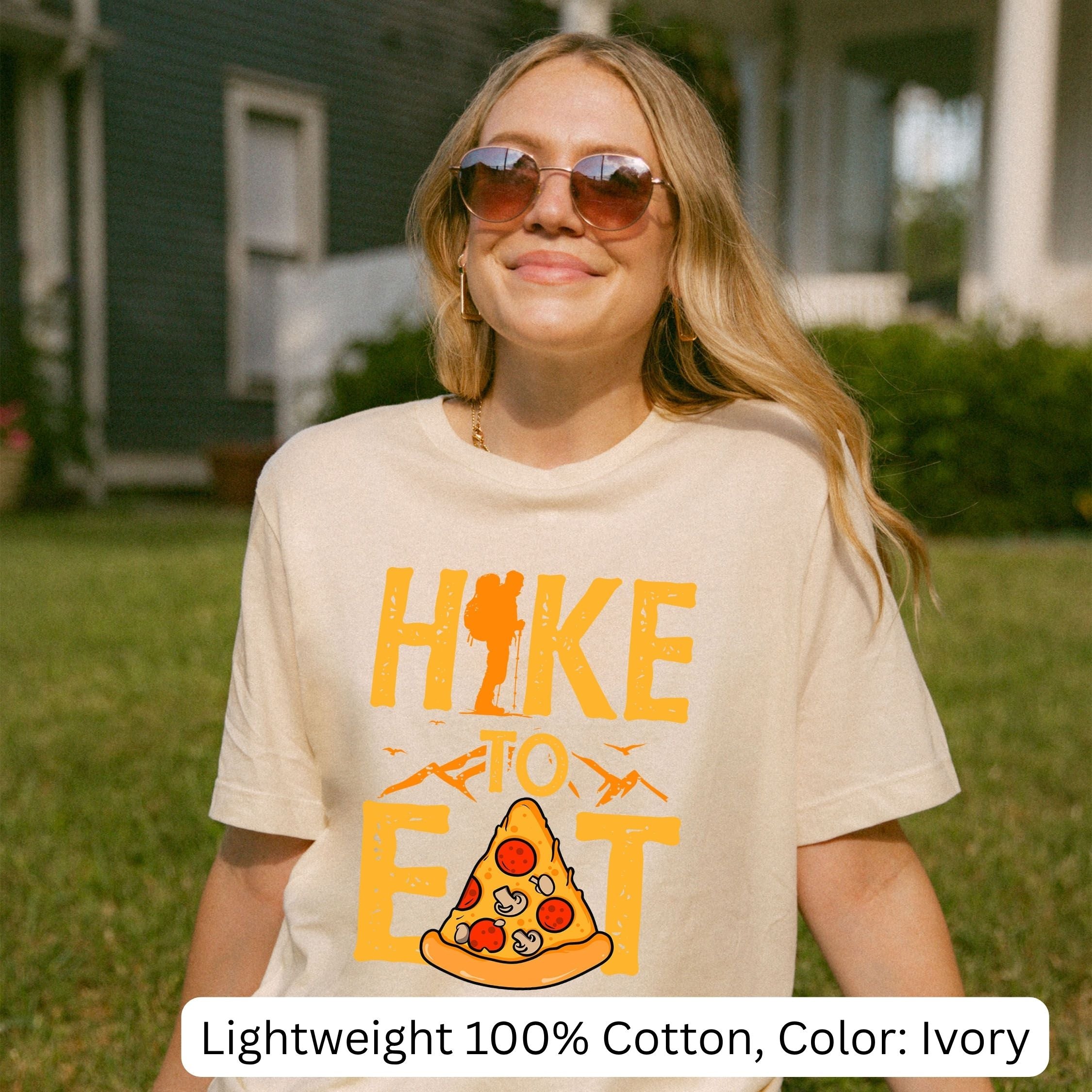 Woman wearing a ivory t-shirt with a pizza graphic and text outdoors.Lightweight 100% cotton, color:i vory