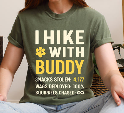 Moss (Dark Green) graphic t-shirt with 'Personalized Trail Companion' design featuring 'I Hike with' text and customizable pet name field in cream and yellow lettering with paw prints, plus hiking stats with customizable snacks stolen number, wags deployed 100%, and squirrels chased infinity.