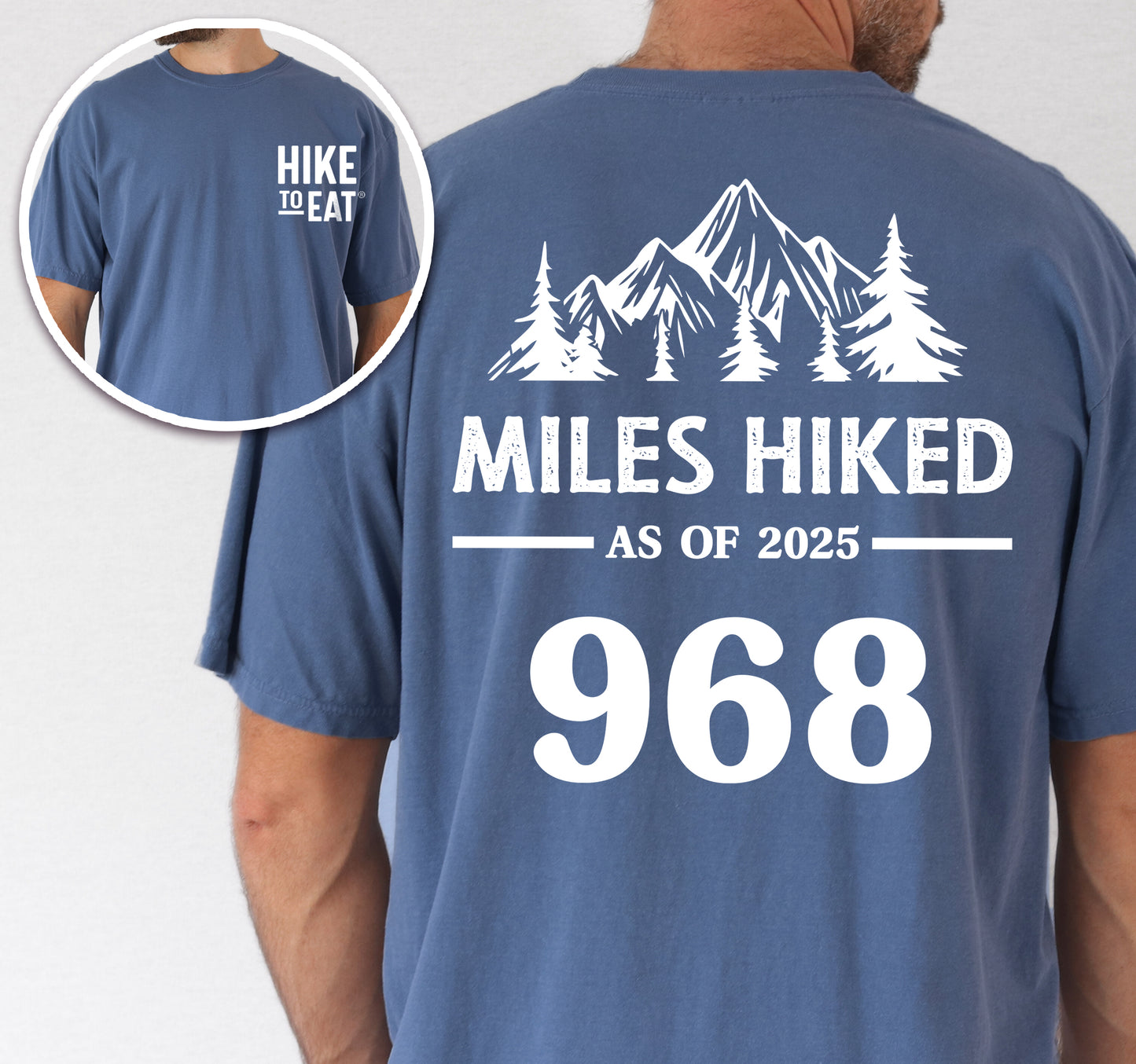 Blue Jean (Denim Blue) Hike to Eat t-shirt front and back view showing small white chest detail and large back design featuring 'Milestone Tracker Personalized' with mountain and pine tree silhouettes, 'Miles Hiked as of 2025' text and customizable numbers field, displaying example number 968.