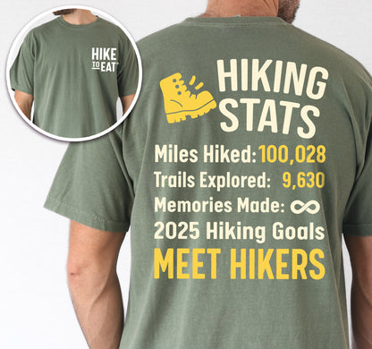 Moss (Dark Green) Hike to Eat t-shirt front and back view showing small chest detail and large back design featuring 'Hiking Stats Personalized' with yellow hiking boot icon, customizable miles hiked and trails explored numbers, memories made infinity, and customizable 2025 hiking goals, displaying example stats and 'Meet Hikers' goal.