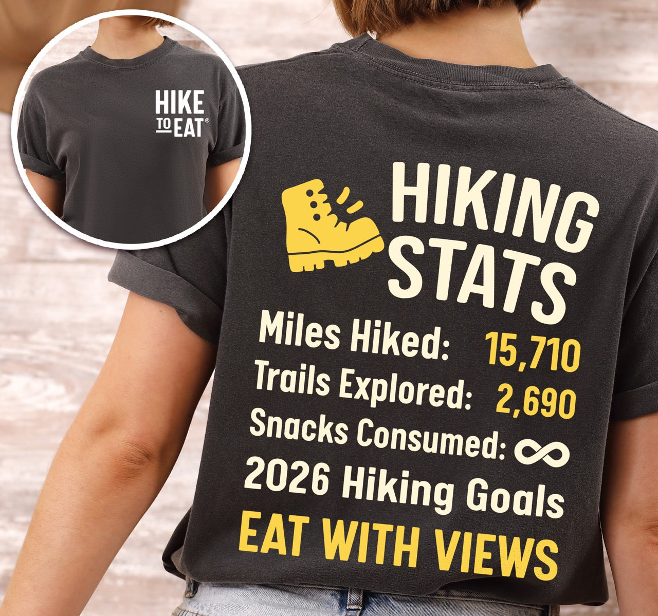 Woman wearing Pepper colored Hiking Snack Stats t shirt with miles hiked, trail explored, snack consumed as infinity and a 2026 hiking goal choice of earn every bite