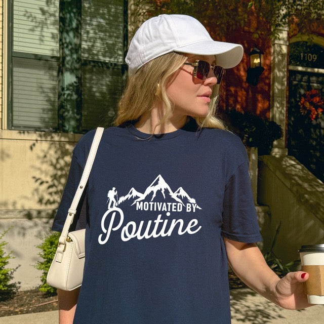 woman wearing Navy (blue) Cornsilk (yellow) Motivated by Poutine statement tee with distressed typography, mountain peaks, and hiker silhouette for poutine lovers and canadian food lovers