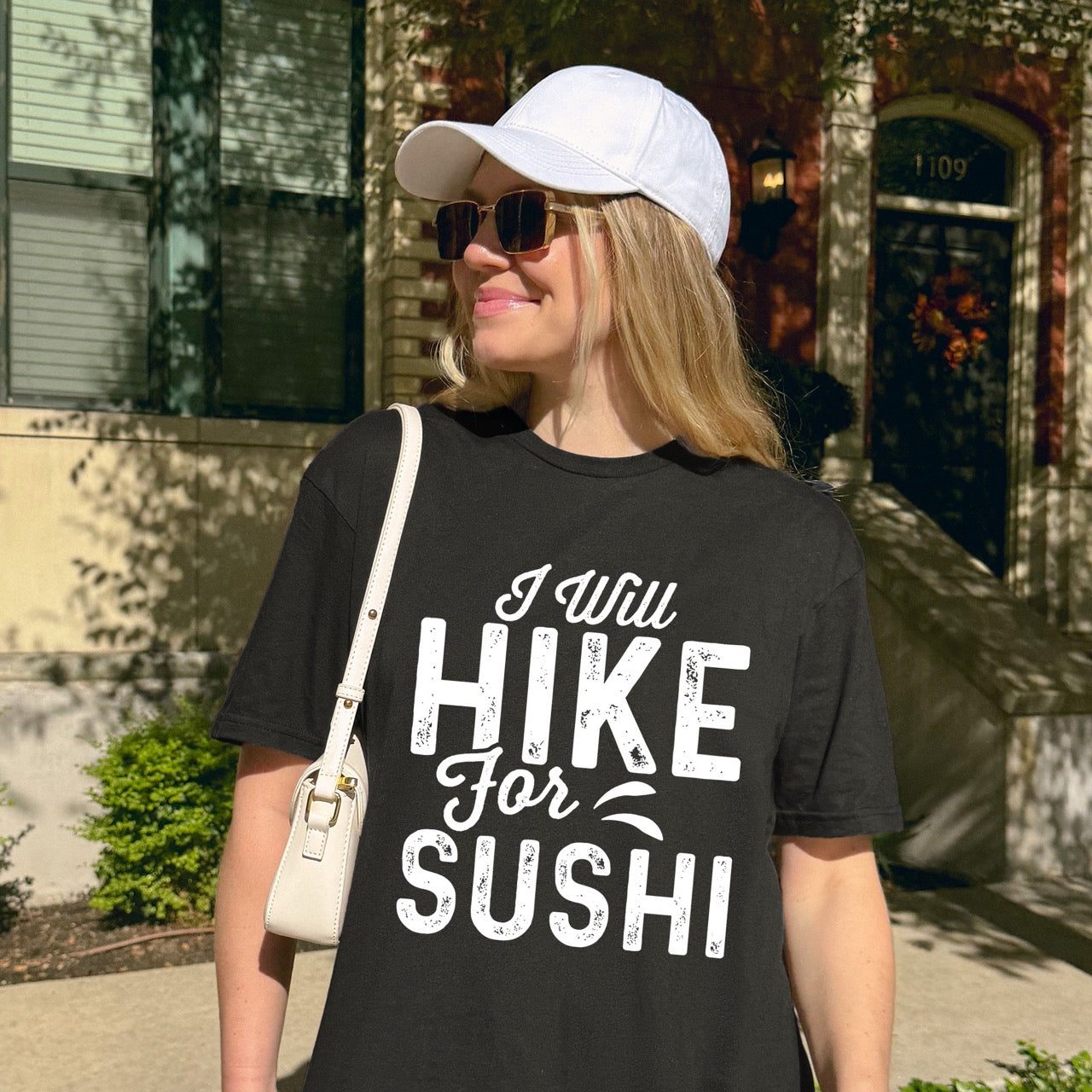 woman wearing black I Will Hike for Sushi statement tee with distressed bold typography and elegant script lettering for Japanese food-loving outdoor enthusiasts and hikers