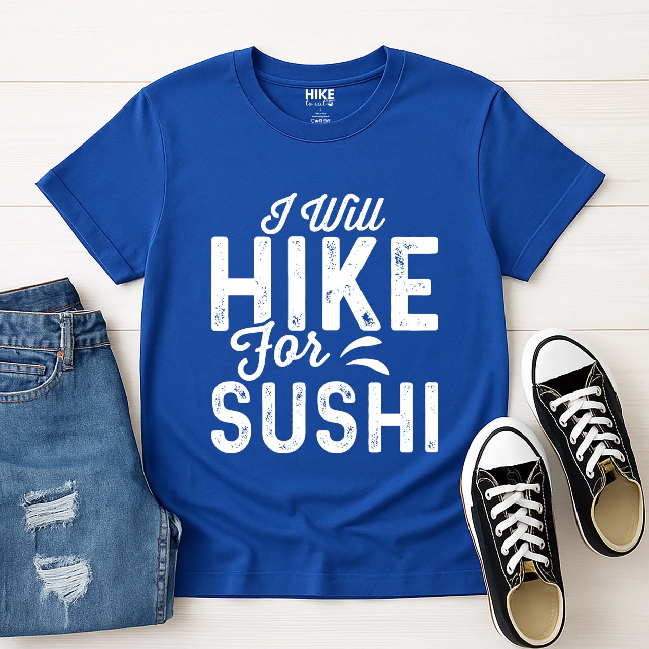 royal blue I Will Hike for Sushi statement tee with distressed bold typography and elegant script lettering for Japanese food-loving outdoor enthusiasts and hikers with jeans and shoes
