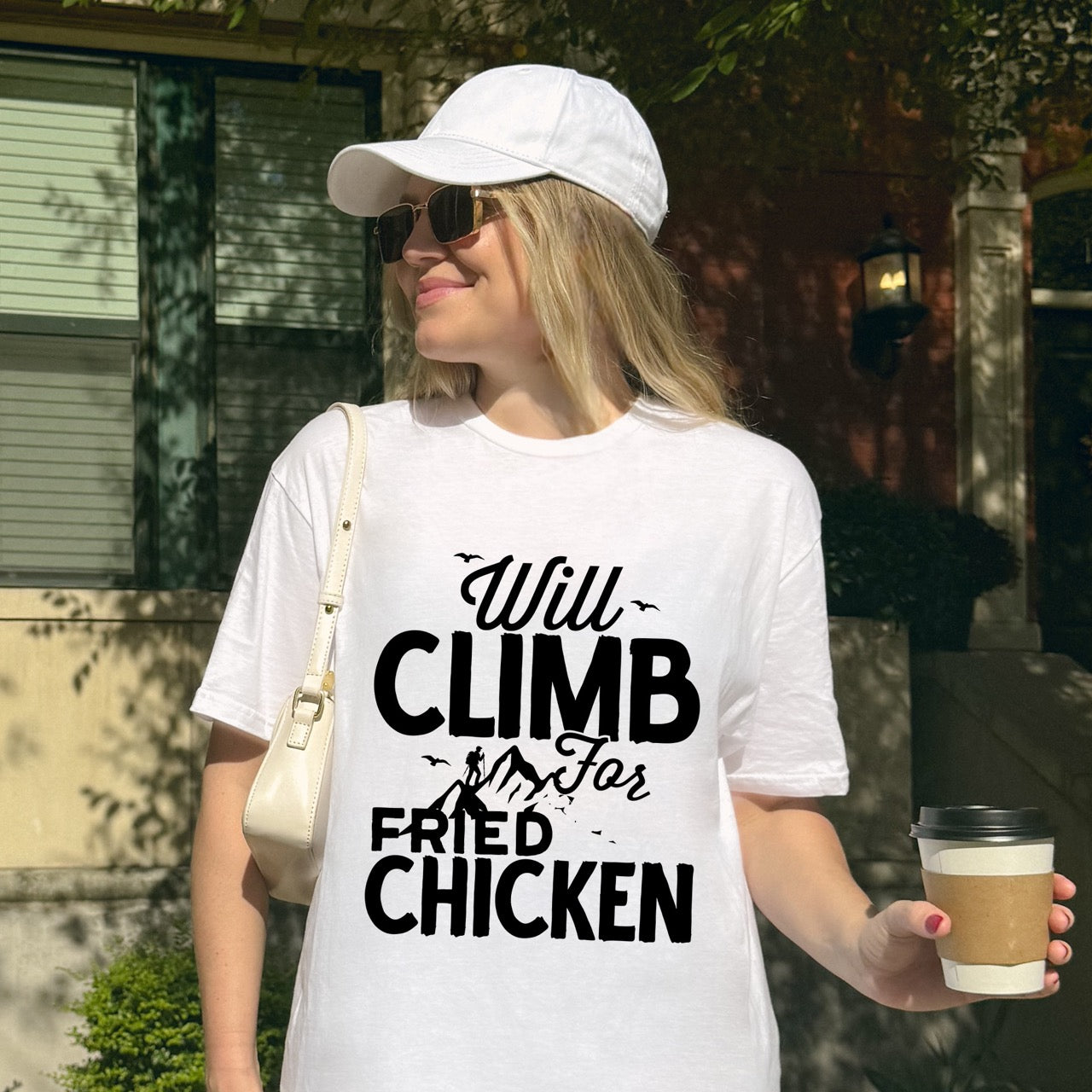 Woman wearing White Will climb for Fried Chicken statement tee with bold and script typography, mountain peaks, climber silhouette, and flying birds for chicken-loving outdoor athletes, climbers, hikers and foodies