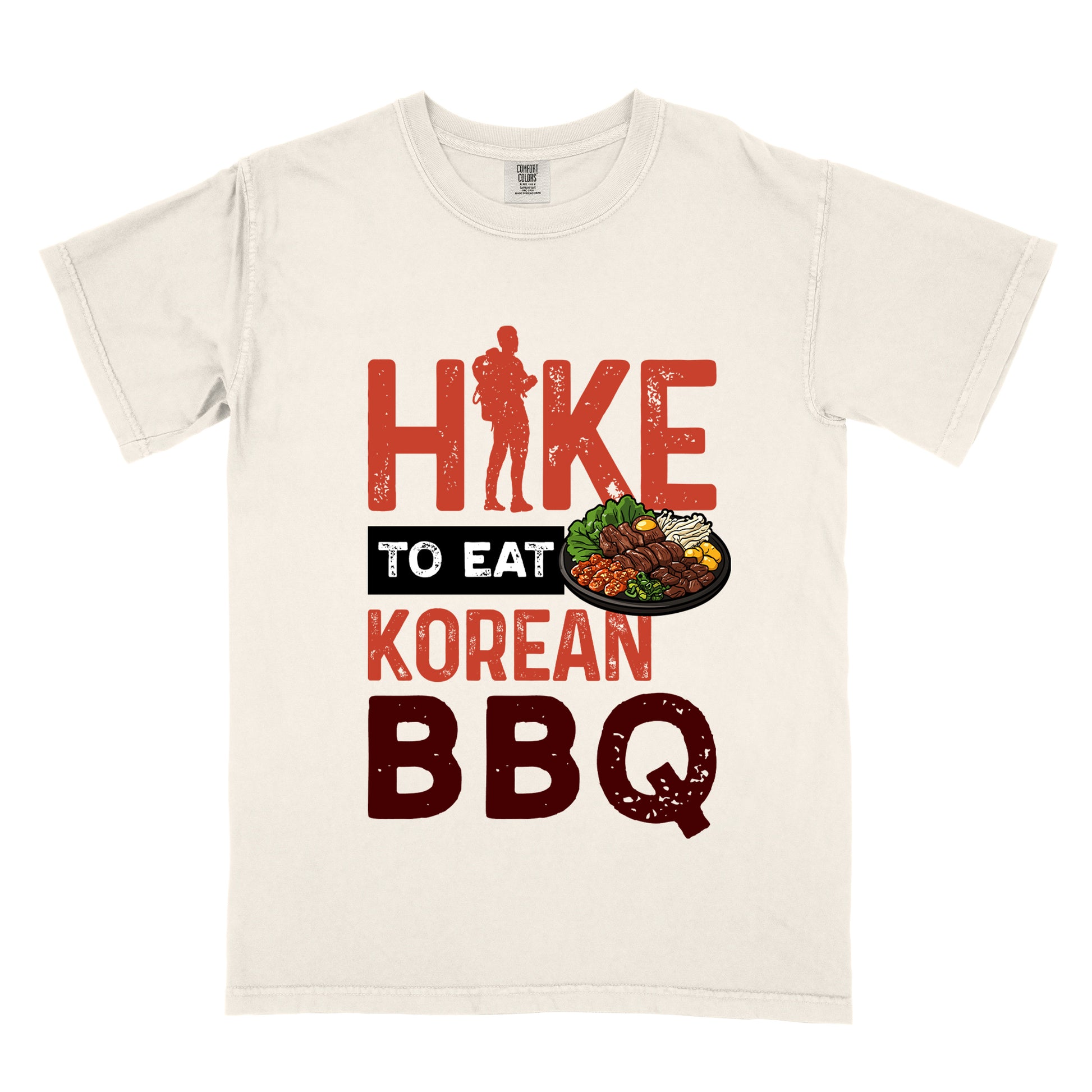 Ivory (Cream White) t-shirt with red and dark red distressed text reading "HIKE TO EAT KOREAN BBQ". "HIKE" appears in large red letters at the top with a red hiker silhouette integrated into the letter "I", "TO EAT" in white text on a black rectangular background in the middle, "KOREAN" in red, and "BBQ" in dark red at the bottom. Features an illustration of Korean barbecue with meat and vegetables on a black plate extending from the black background.
