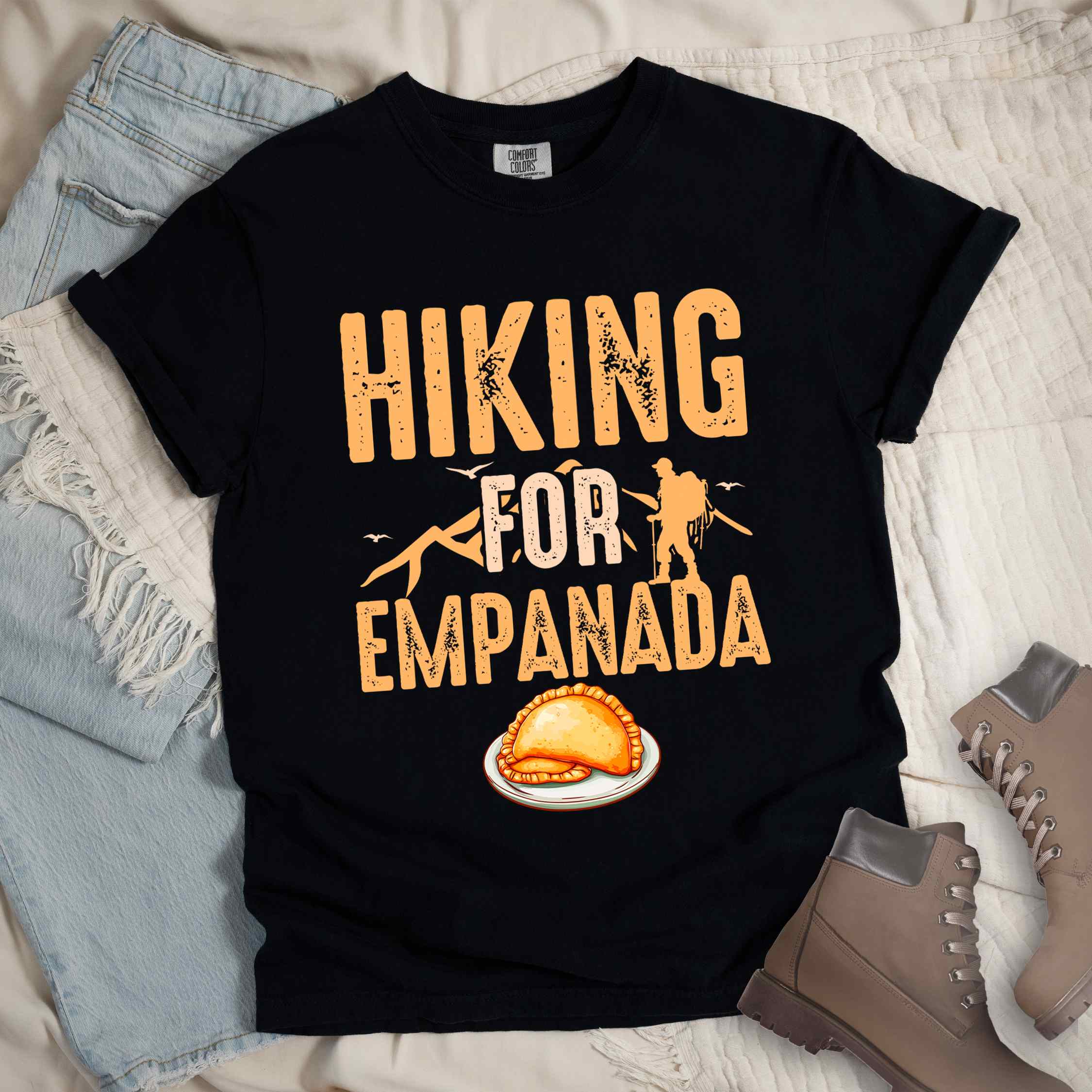 black "Hiking for empanada" colored vintage tee with bold typography, illustrated freshly baked empanada, mountains, birds, and backpackers for asian cuisine enthusiasts.