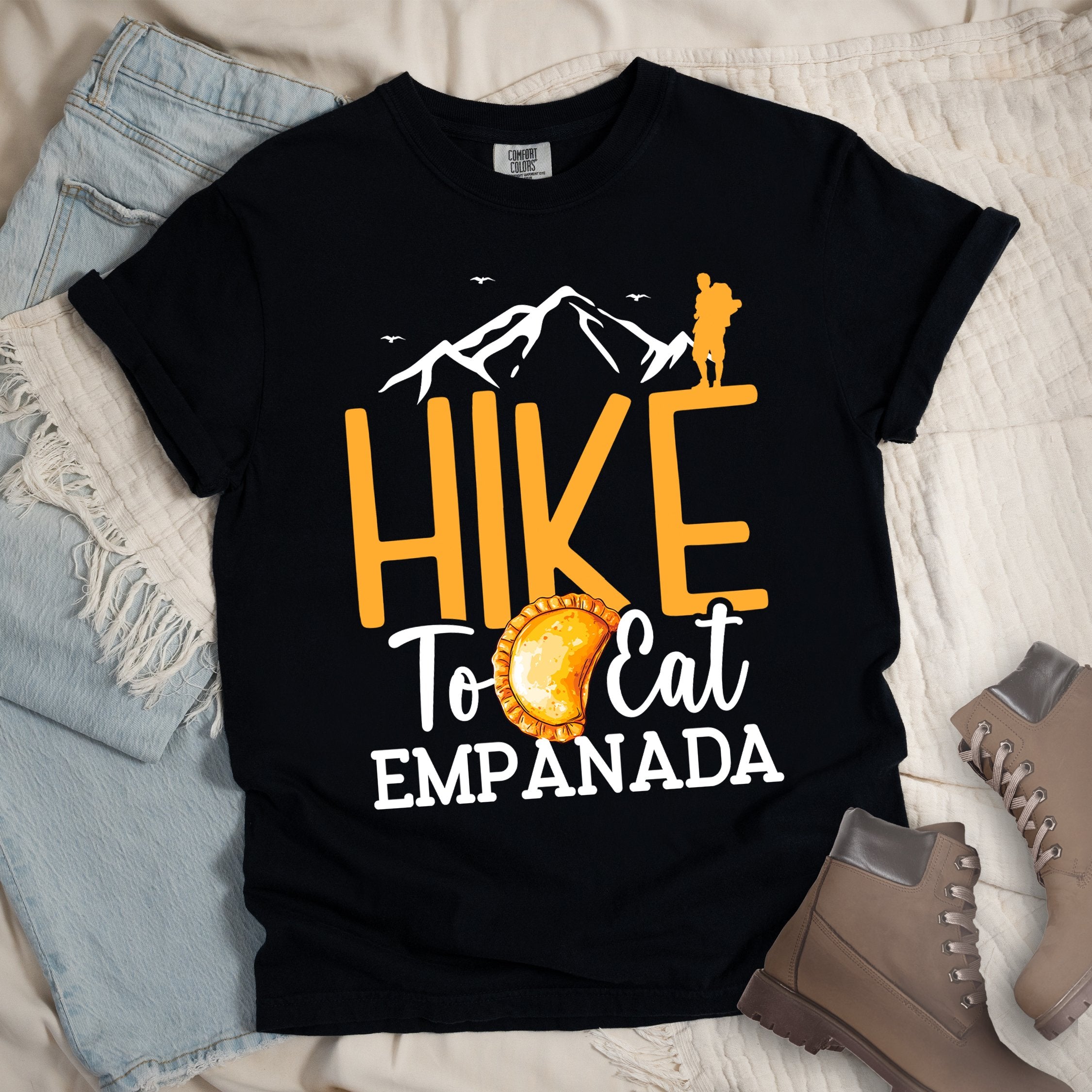 Black shirt with Hiking Design featuring the phrase “Hike to Eat Empanada” and a hiker silhouette above a plate of empanada.