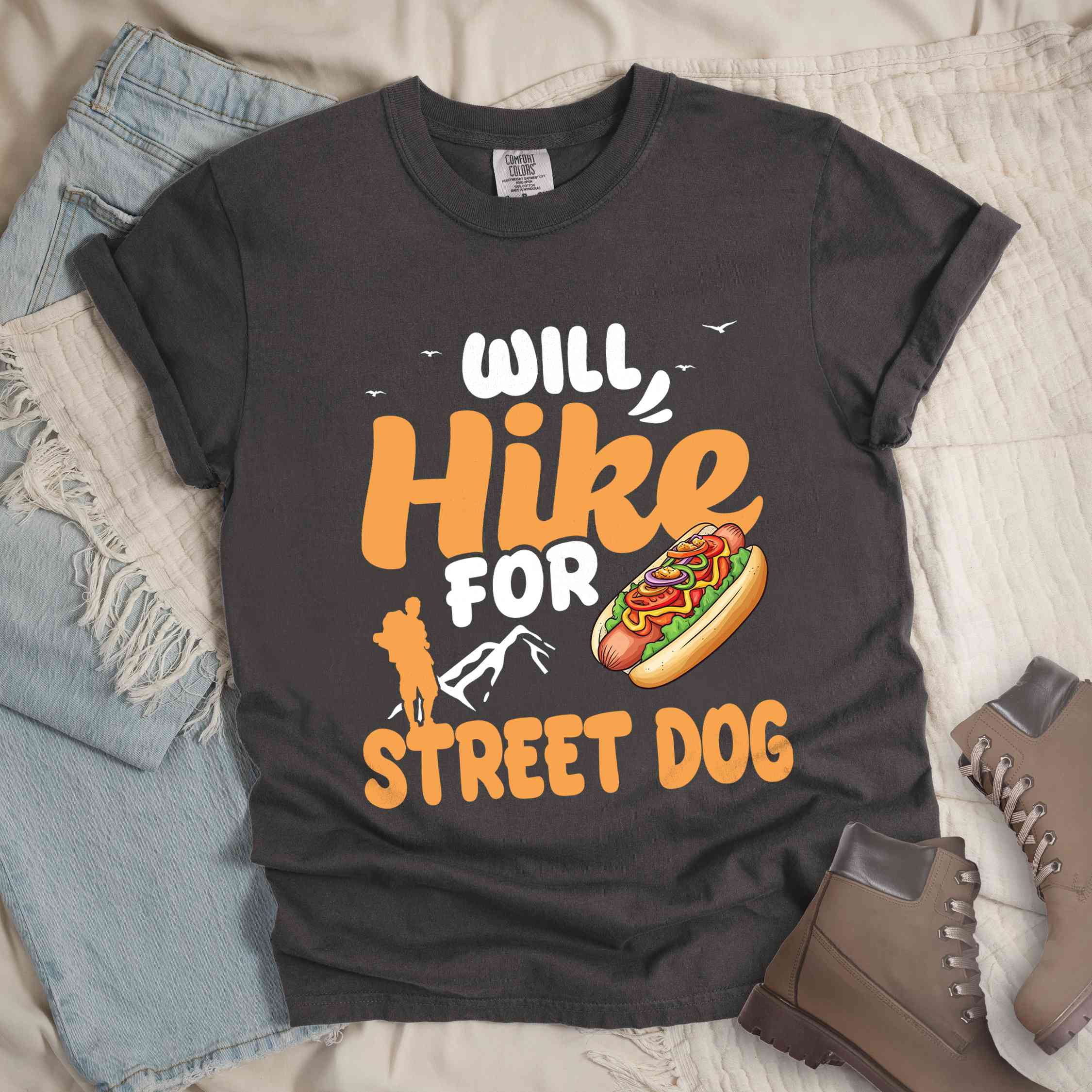 Pepper "Will hike for street dog" colored vintage tee with bold typography, illustrated freshly bratwurst in a bun, mountains, birds, and backpackers for street dog lovers.