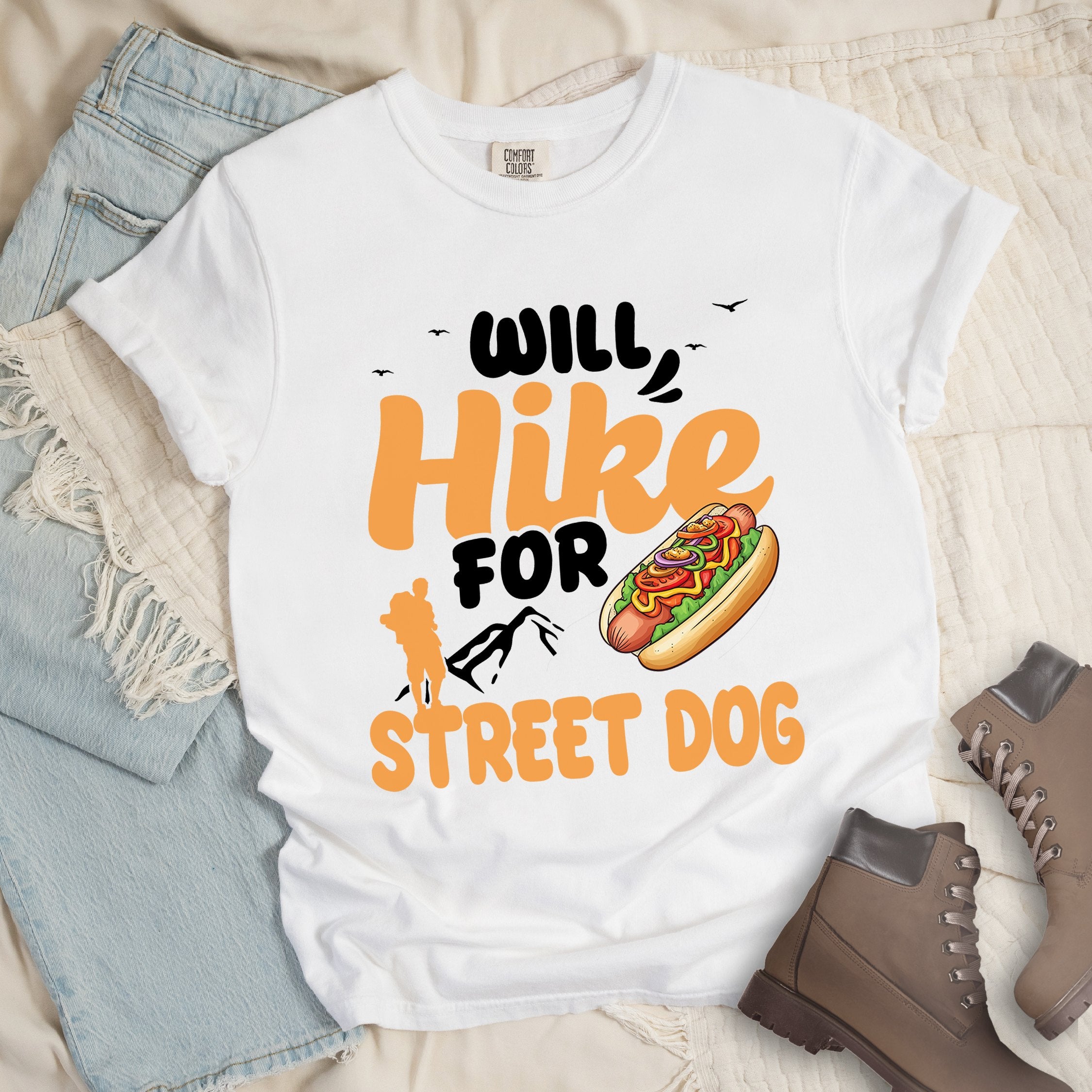 White shirt with Hiking Design featuring the phrase “Will Hike for Street Dog” and an illustration of a hot dog with toppings.
