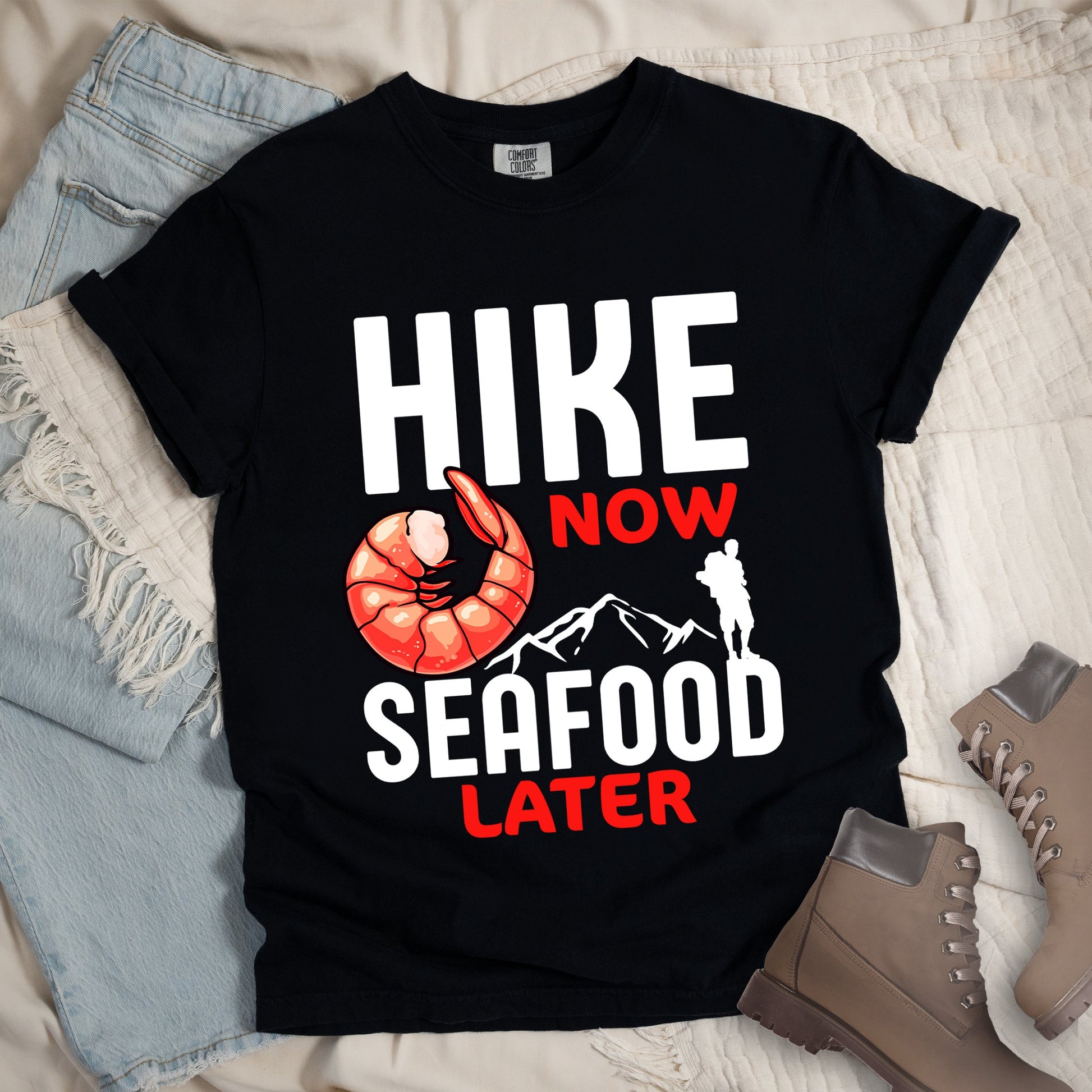 Black shirt with Hiking Design featuring the phrase “Hike Now Seafood Later” and an illustration of a shrimp with a mountain outline.