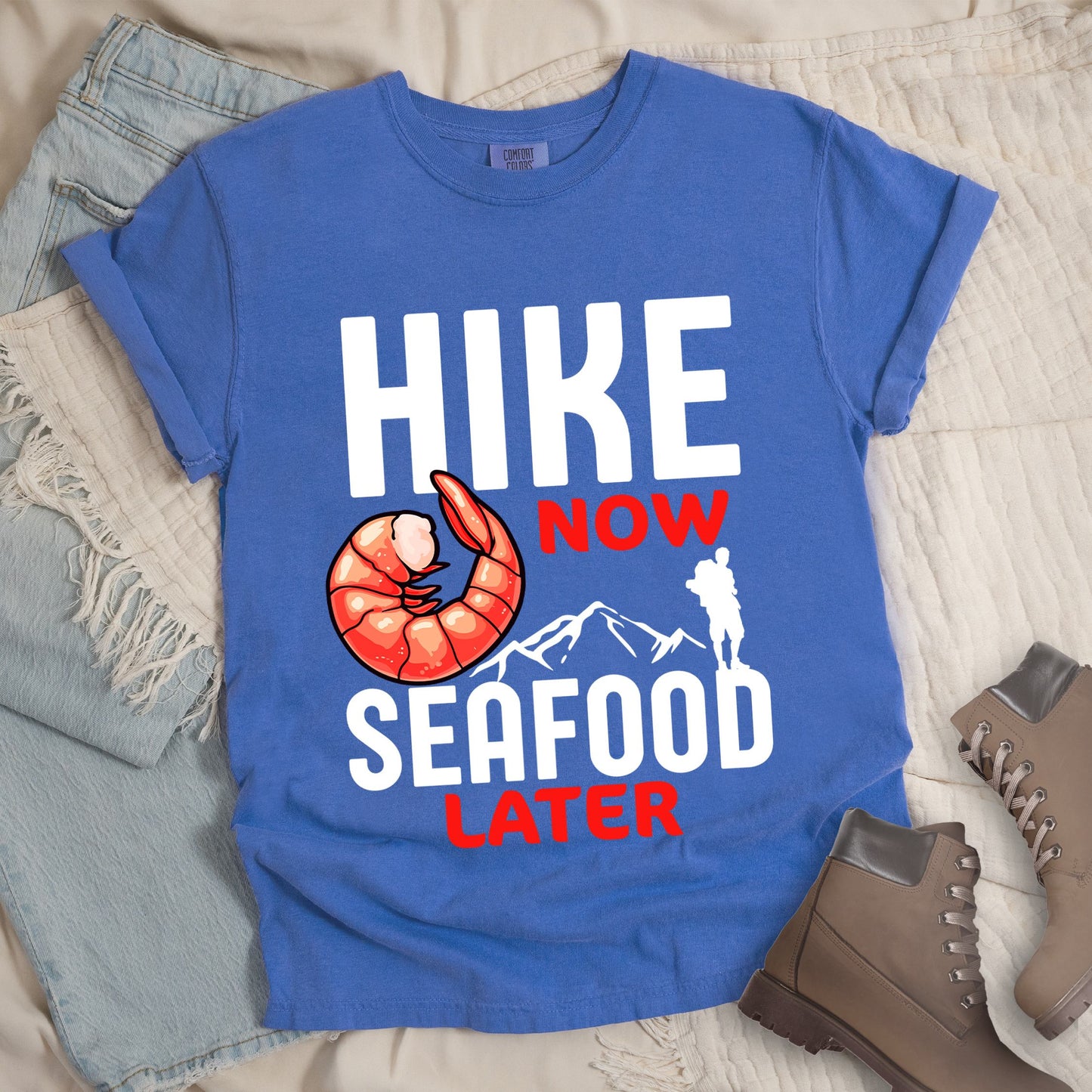 Blue shirt with Hiking Design featuring the phrase “Hike Now Seafood Later” and an illustration of a shrimp with a mountain outline.