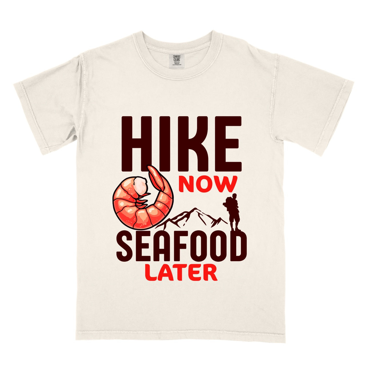 Funny hiking motivation shirt for seafood lovers featuring bold NOW LATER typography, realistic shrimp graphic, mountain landscape illustration, and hiker silhouette on premium outdoor adventure tee perfect gift for trail enthusiasts who love fresh ocean food in ivory (beige)