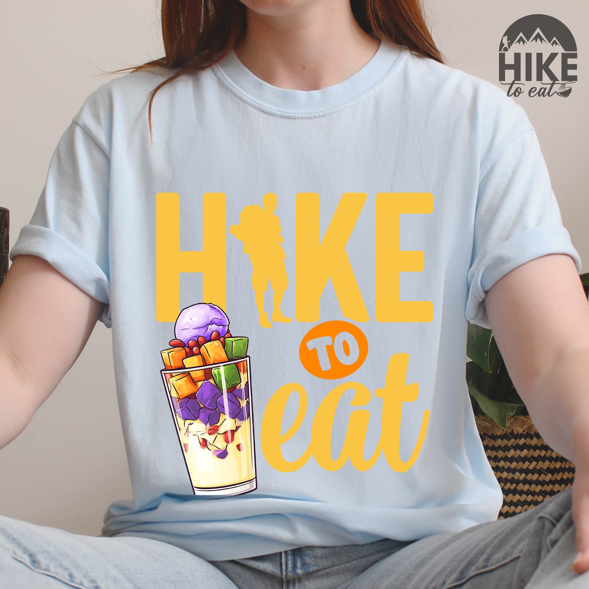 Woman wearing chambray "hike to eat" colored vintage tee with bold typography, illustrated halo-halo dessert, and backpackers for iced dessert lovers.