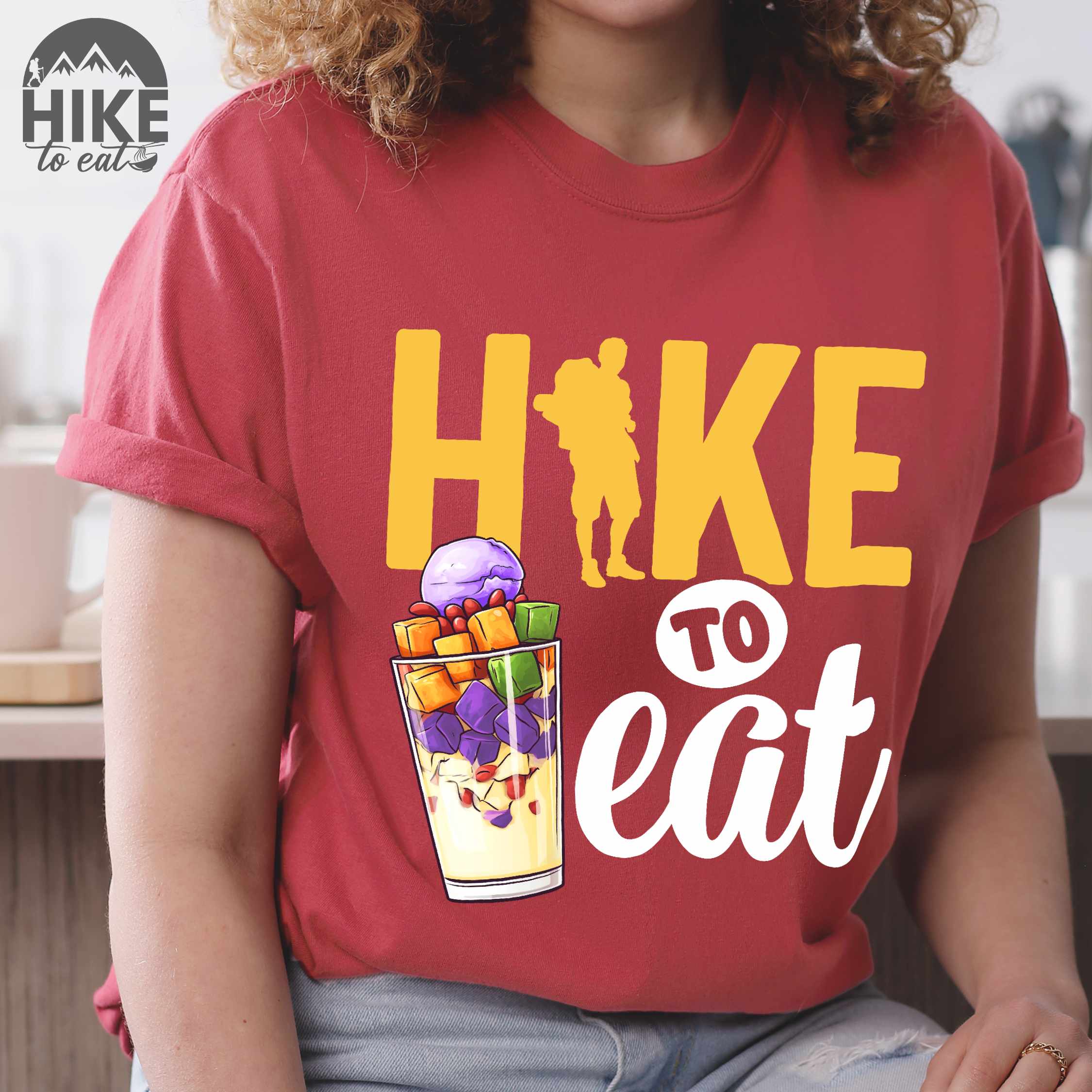 woman wearing crimson "hike to eat" colored vintage tee with bold typography, illustrated halo-halo dessert, and backpackers for iced dessert lovers.
