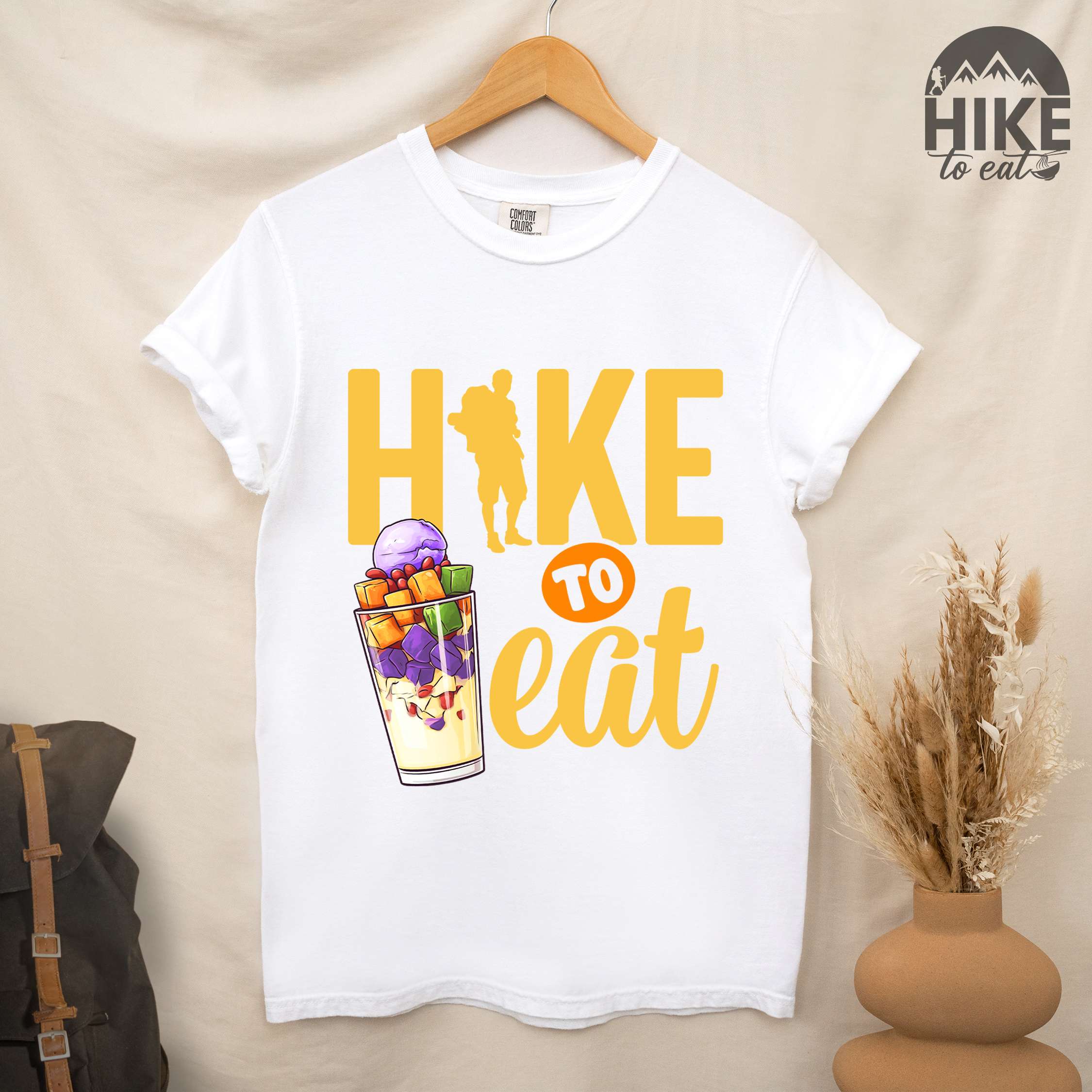 Hanging white "hike to eat" colored vintage tee with bold typography, illustrated halo-halo dessert, and backpackers for iced dessert lovers.