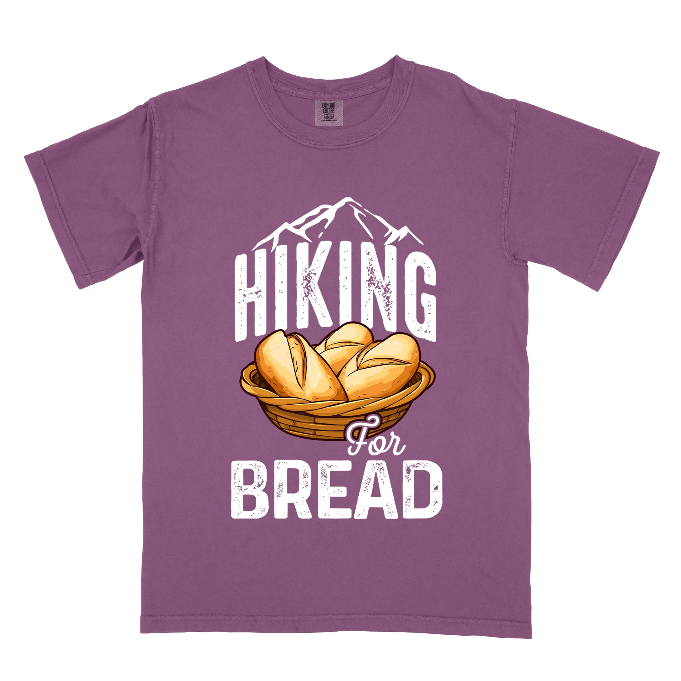 Berry "Hiking for bread" colored statement tee with flowing script typography, bold lettering, and freshly baked bread illustration for pastry-loving outdoor enthusiasts, hikers and foodies
