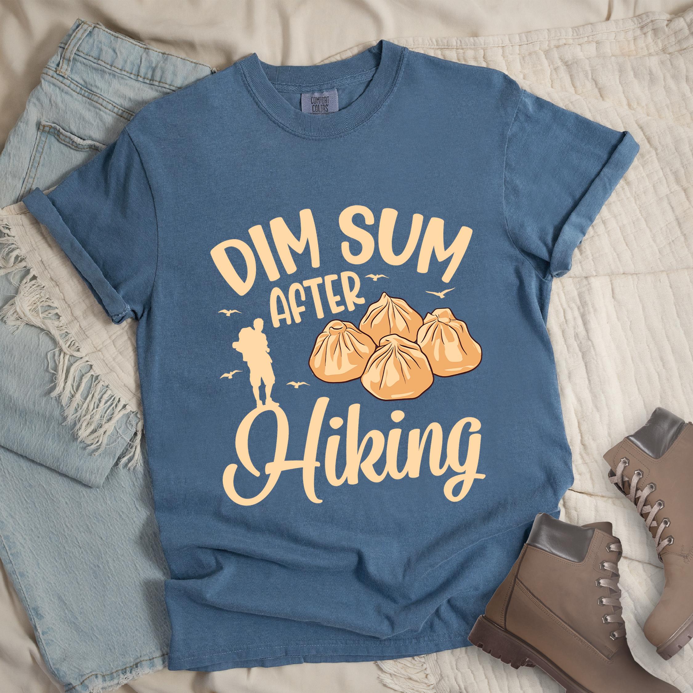 Dark blue shirt with Hiking Design featuring the phrase “Dim Sum After Hiking” with a hiker silhouette and a group of dim sum buns.