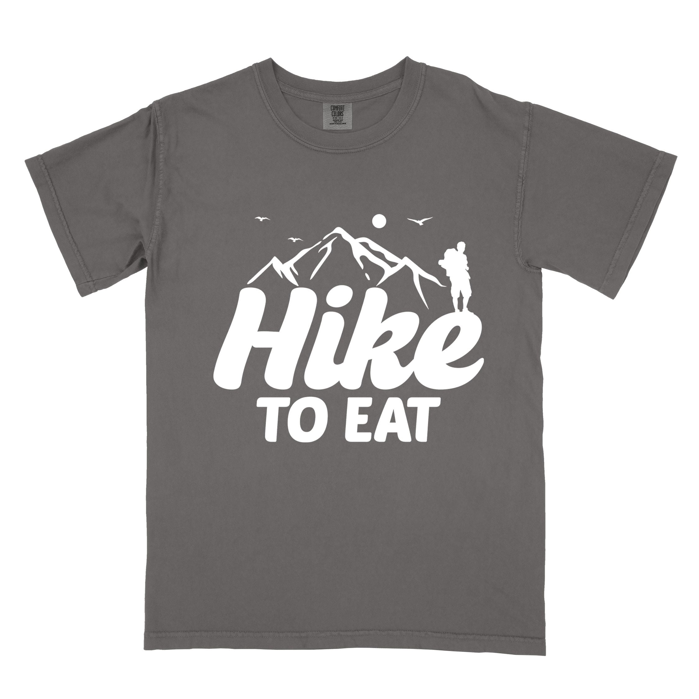 pepper "Hike to Eat" colored statement tee with bold typography, mountains, birds, sunrise, perfect for food motivated individuals.