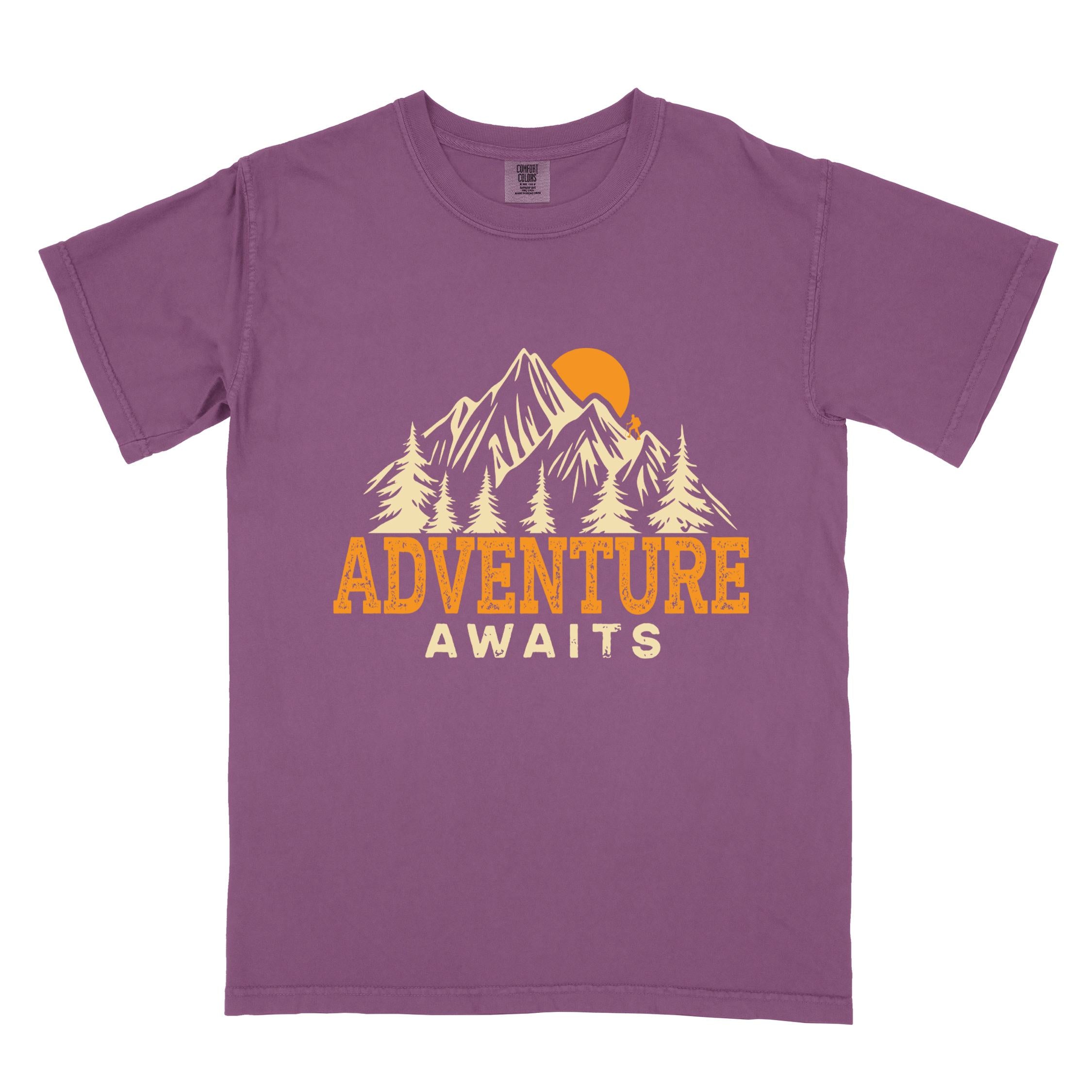 Berry "Adventure Awaits" colored statement tee with bold typography, mountains, birds, perfect for adventure motivated individuals.