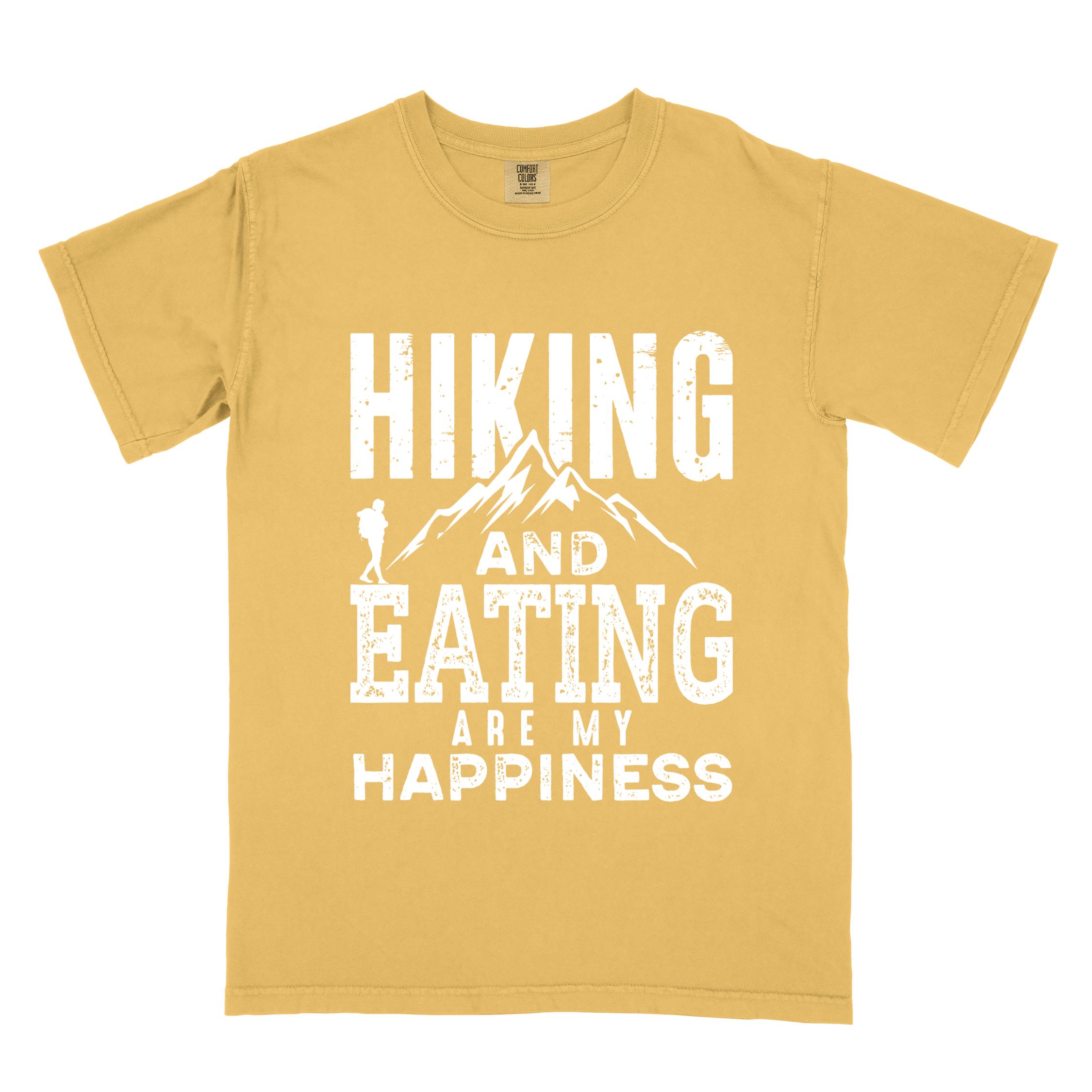 Mustard "Hiking and Eating are my happiness" colored statement tee with bold typography, mountains, birds, perfect for adventure motivated individuals.