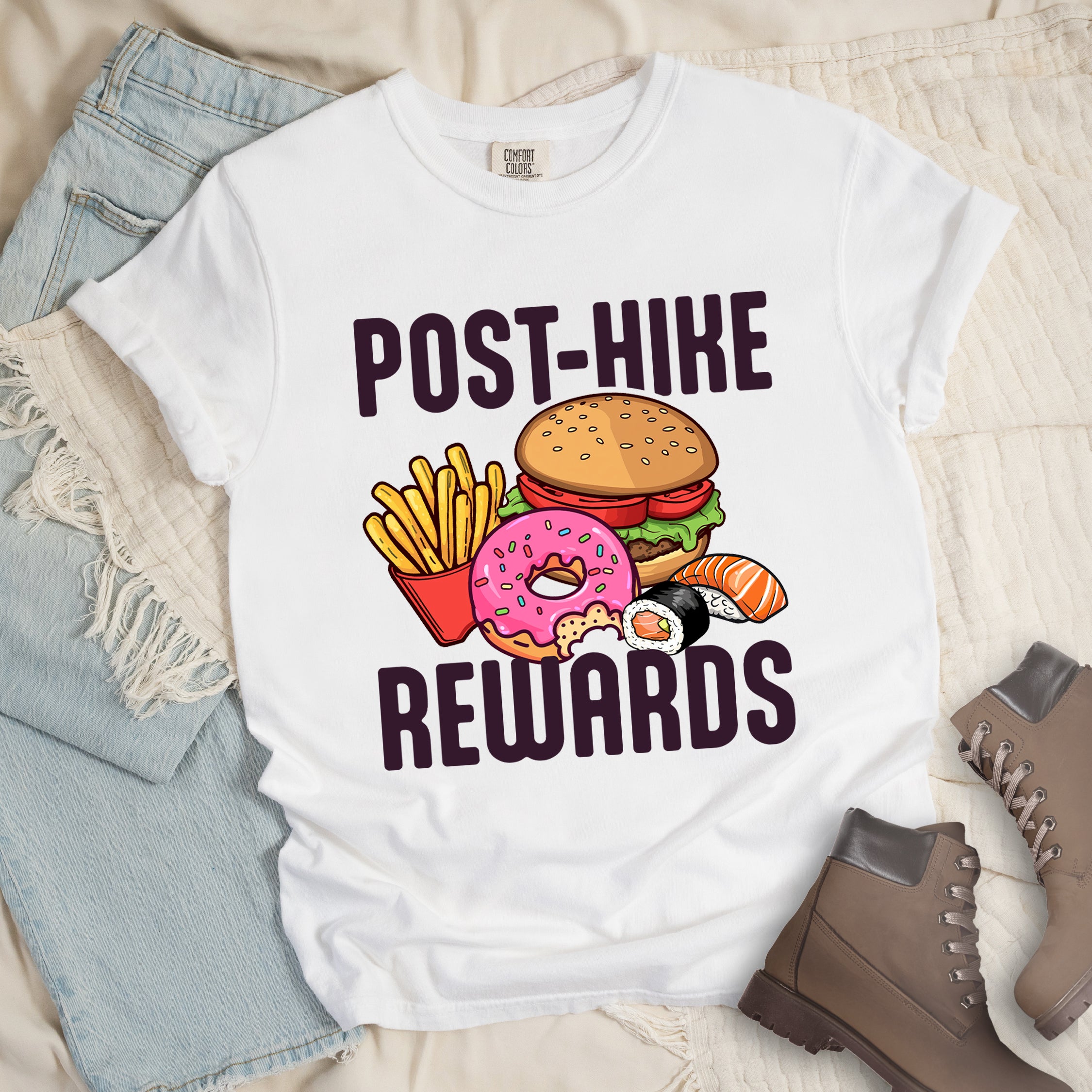 White colored hiking shirt displaying deep purple POST-HIKE REWARDS text with colorful burger, french fries, donut, and sushi illustrations