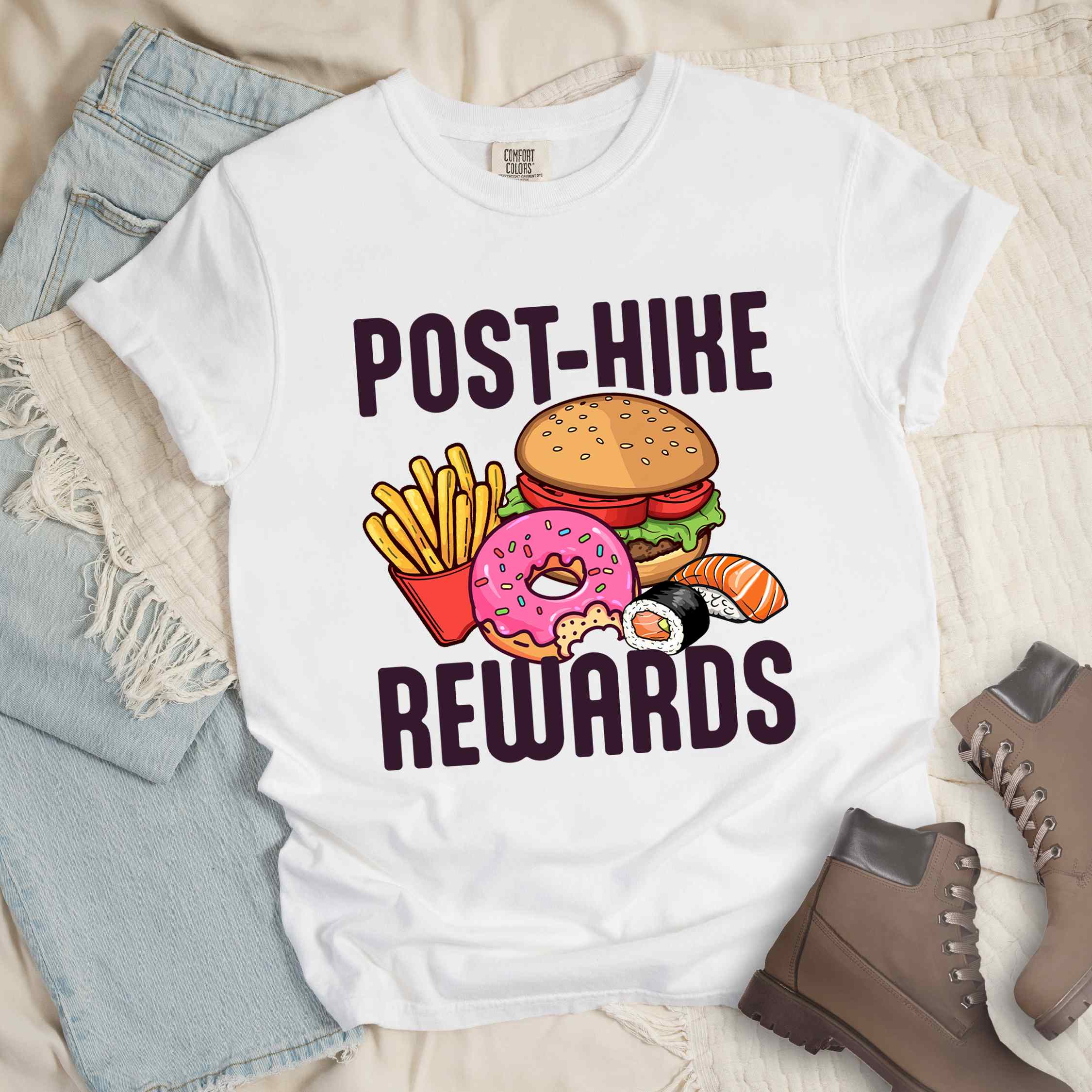 White "Post-hike rewards" colored statement tee with bold typography, mountains, birds, illustrated fast food meal, perfect for adventure motivated individuals and looking for post-hike meal.