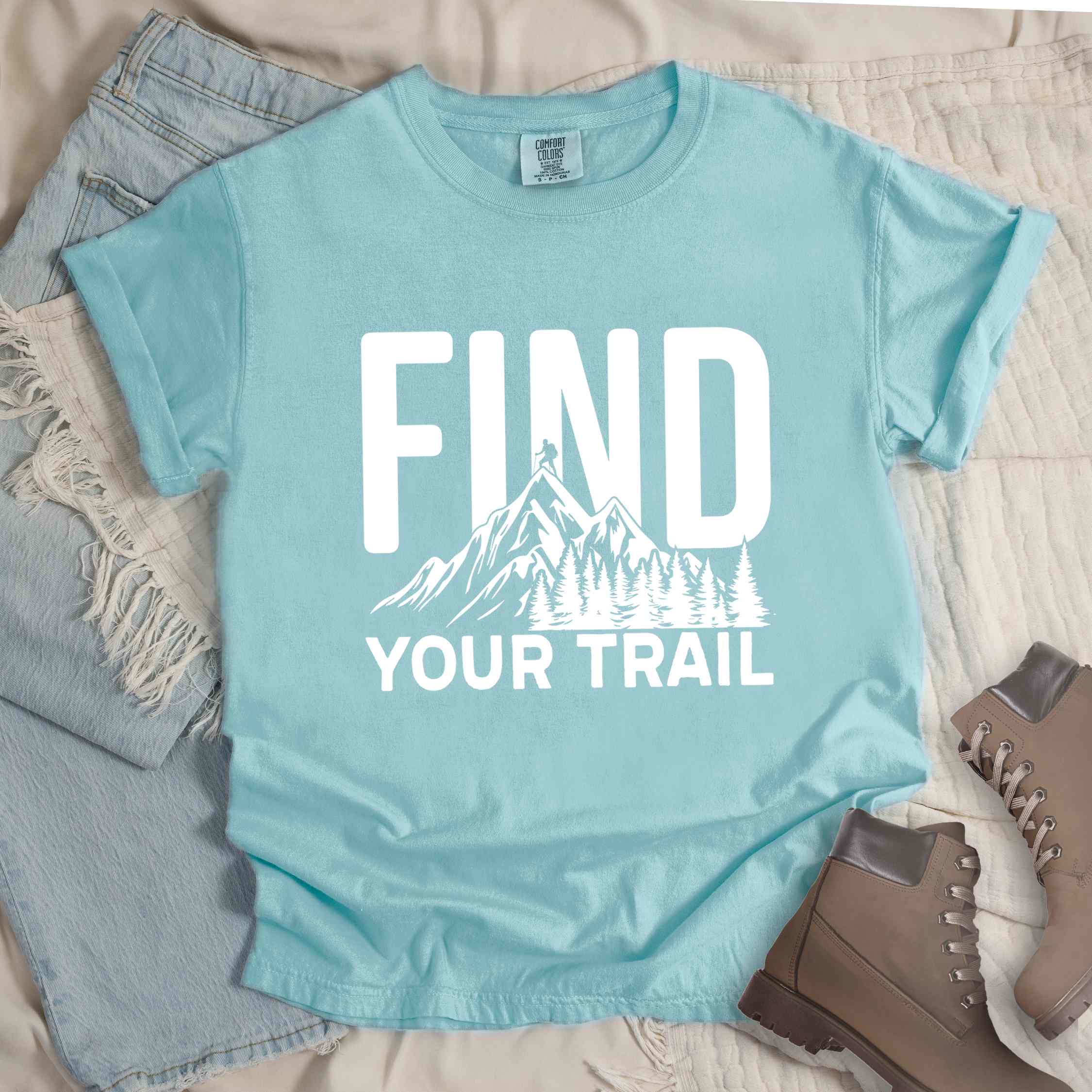 Chalky mint "Find your trail" colored statement tee with bold typography, mountains, birds, perfect for adventure motivated individuals.
