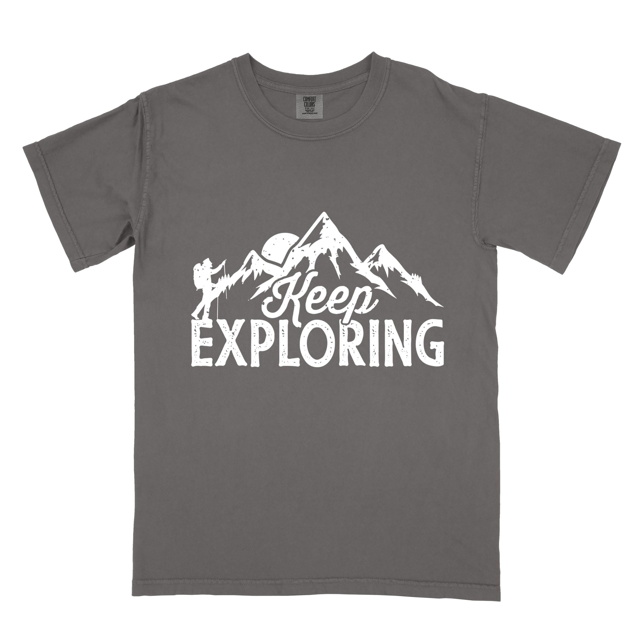Pepper "Keep Exploring" colored statement tee with bold typography, mountains, birds, perfect for adventure motivated individuals.