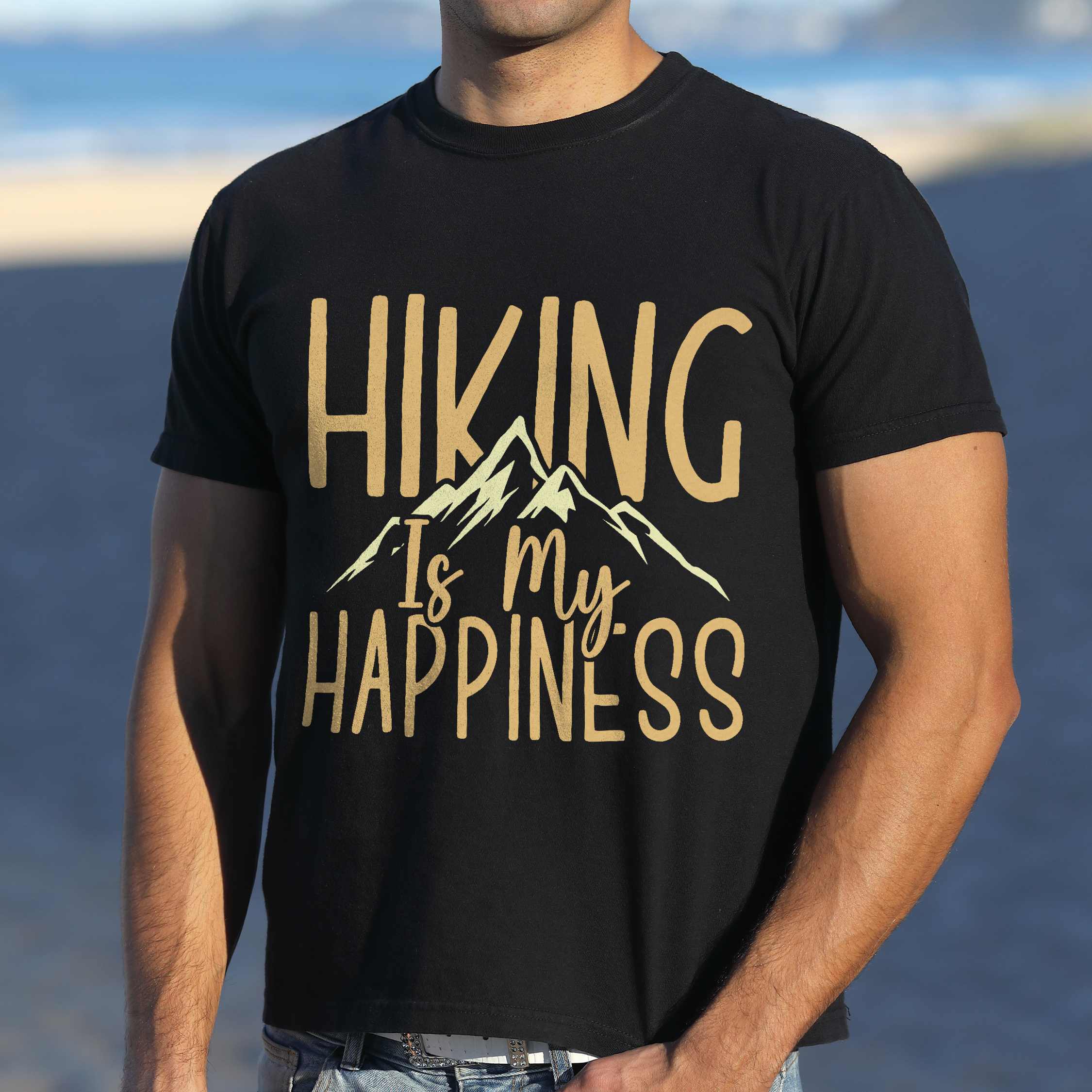 Man wearing black "hiking is my happiness" colored statement tee with bold typography, mountain, sunrise, perfect for adventure motivated individuals.