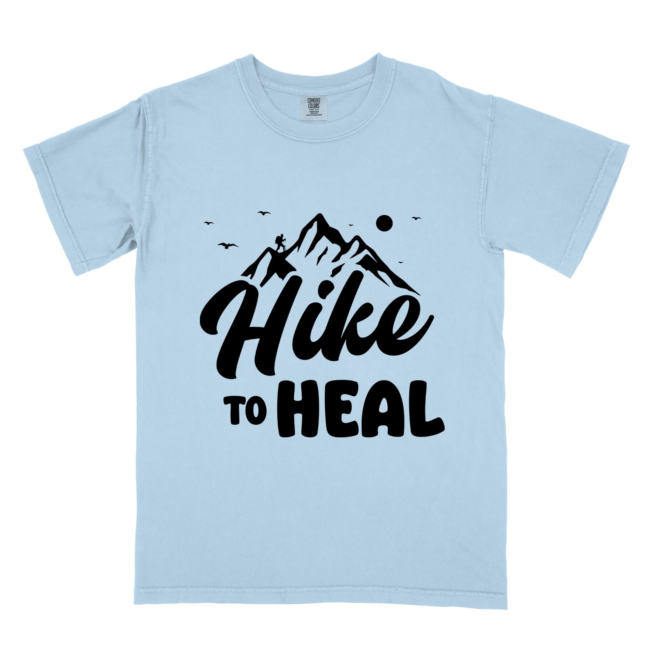 Chambray "Hike to Heal" colored statement tee with bold typography, mountain, sunrise, perfect for adventure driven individuals.