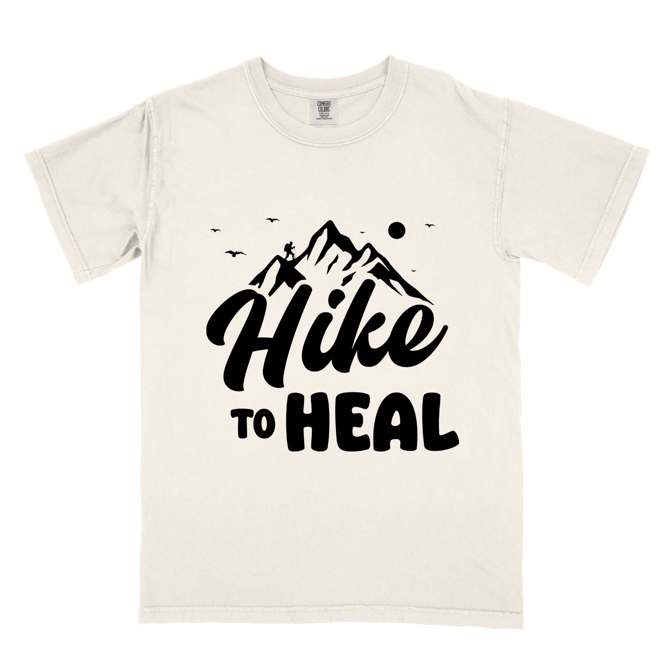 Ivory "Hike to Heal" colored statement tee with bold typography, mountain, sunrise, perfect for adventure driven individuals.