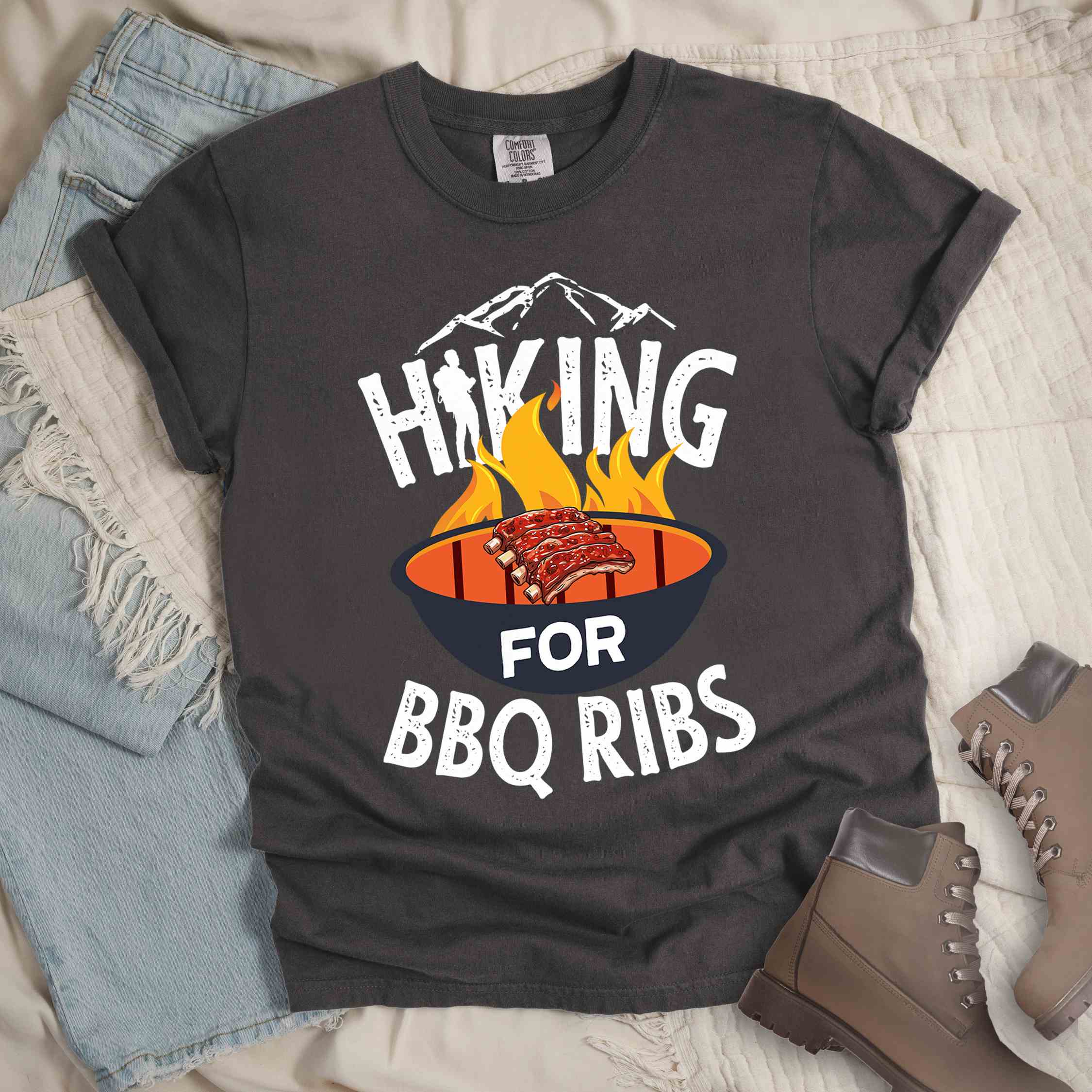 Pepper Hiking for BBQ ribs colored vintage tee with bold typography, illustrated grilling bbq ribs, mountains, birds, and bbq enthusiasts