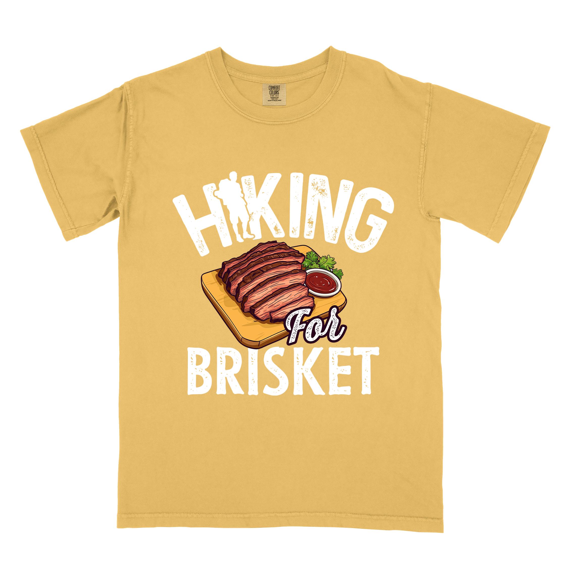 Mustard Hiking for brisket colored vintage tee with bold typography, illustrated sliced brisket, birds, and backpacker for brisket lovers
